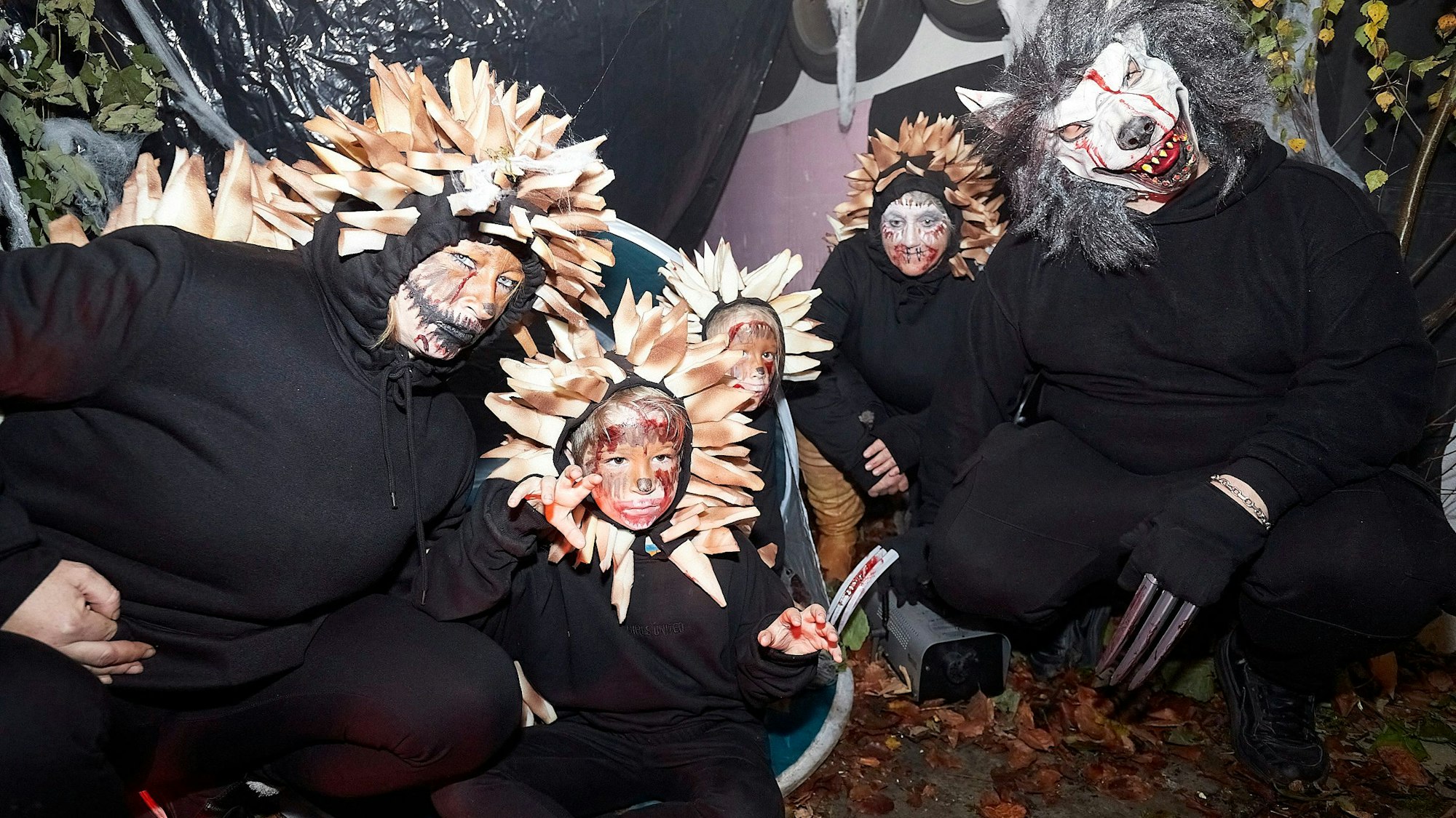 Die kostümierte Gruppe, zwei Erwachsene und drei Kinder, hockt am Boden.