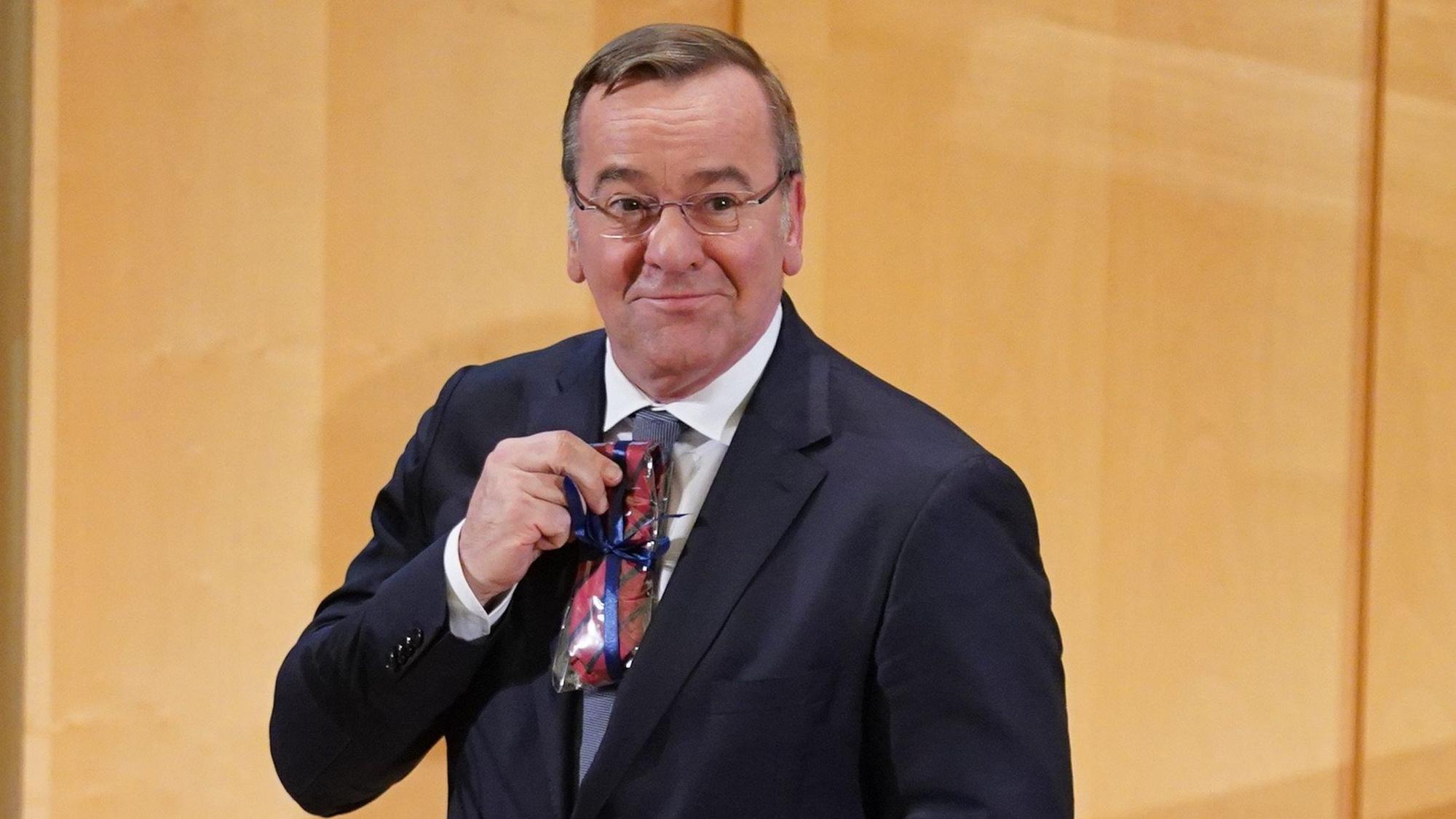 27.10.2023, Hamburg: Boris Pistorius (SPD), Bundesminister der Verteidigung, hält sein Geschenk, eine Krawatte der Bucerius Law School, nach seinem Besuch in der Bucerius Law School hoch. Zuvor hatte der Minister an einer Diskussionsveranstaltung zur Zeitenwende in der deutschen Außen- und Sicherheitspolitik teilgenommen. Foto: Marcus Brandt/dpa +++ dpa-Bildfunk +++