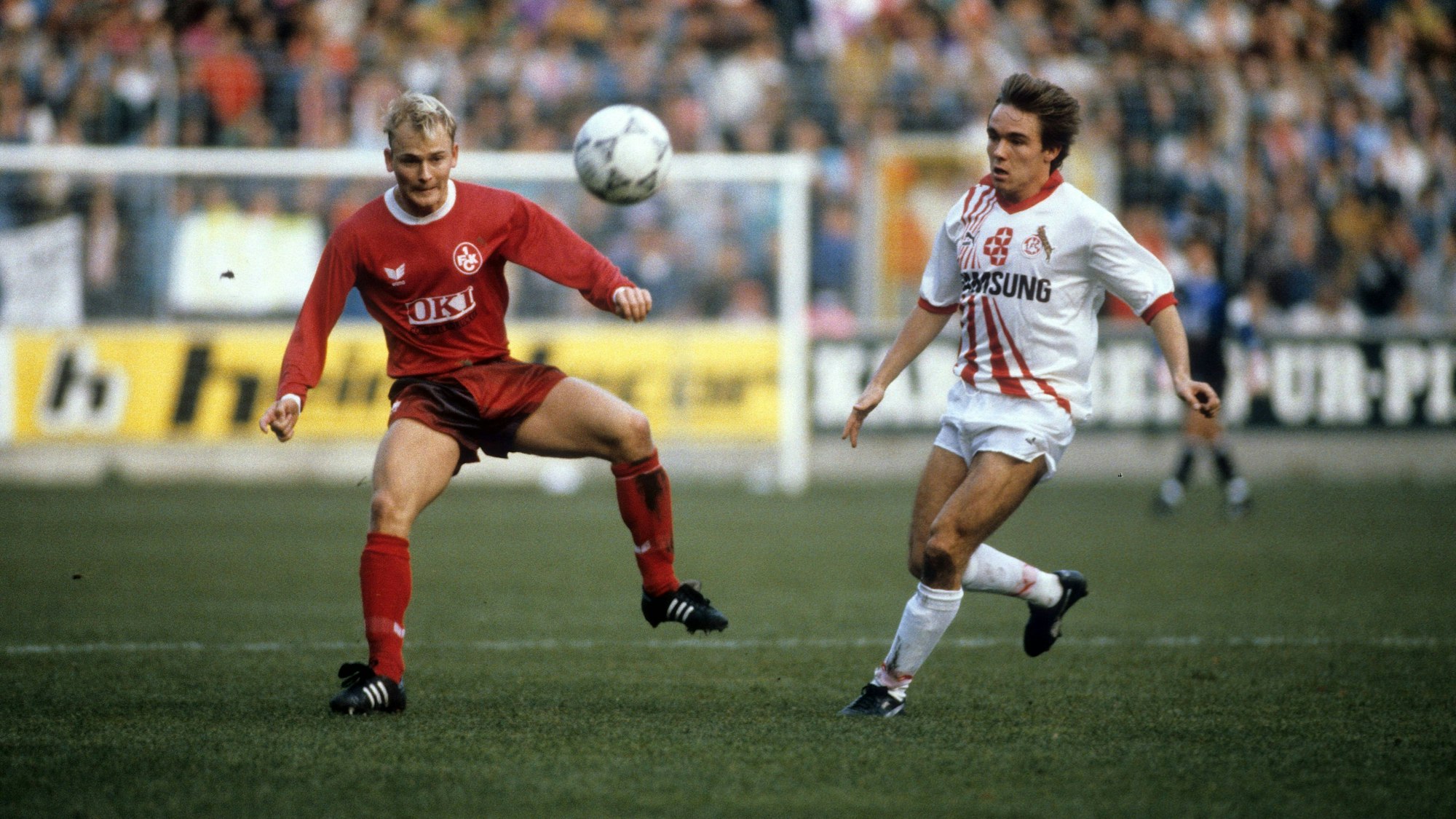 Zwei Fußballspieler kämpfen um den Ball.