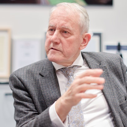 Auf dem Foto ist Louwrens Langevoort zu sehen, er trägt einen grauen Anzug mit Krawatte.