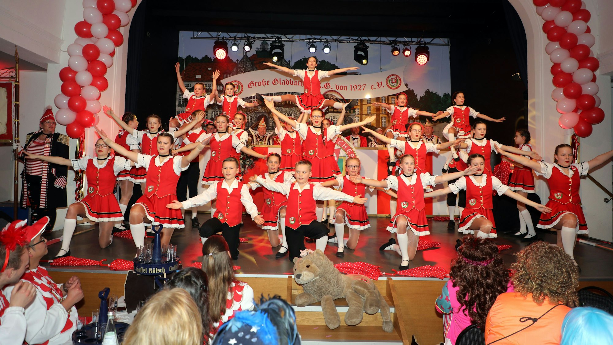 Eine Tanzgruppe präsentiert sich mit ausgebreiteten Armen auf der Bühne des Bocker Saals.