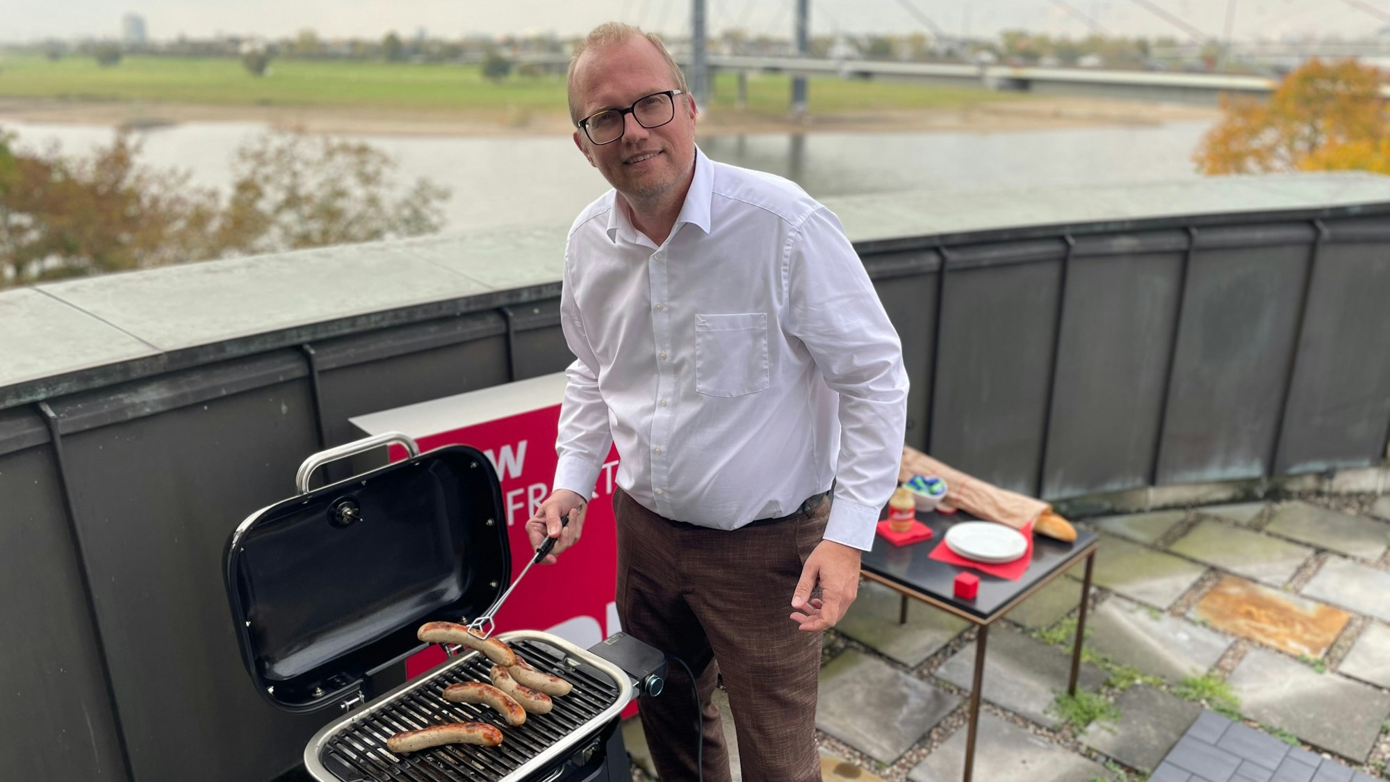 SPD-Chef Ott ist auf der Terrasse seines Büros im NRW-Landtag zu sehen. Er grillt Würstchen.