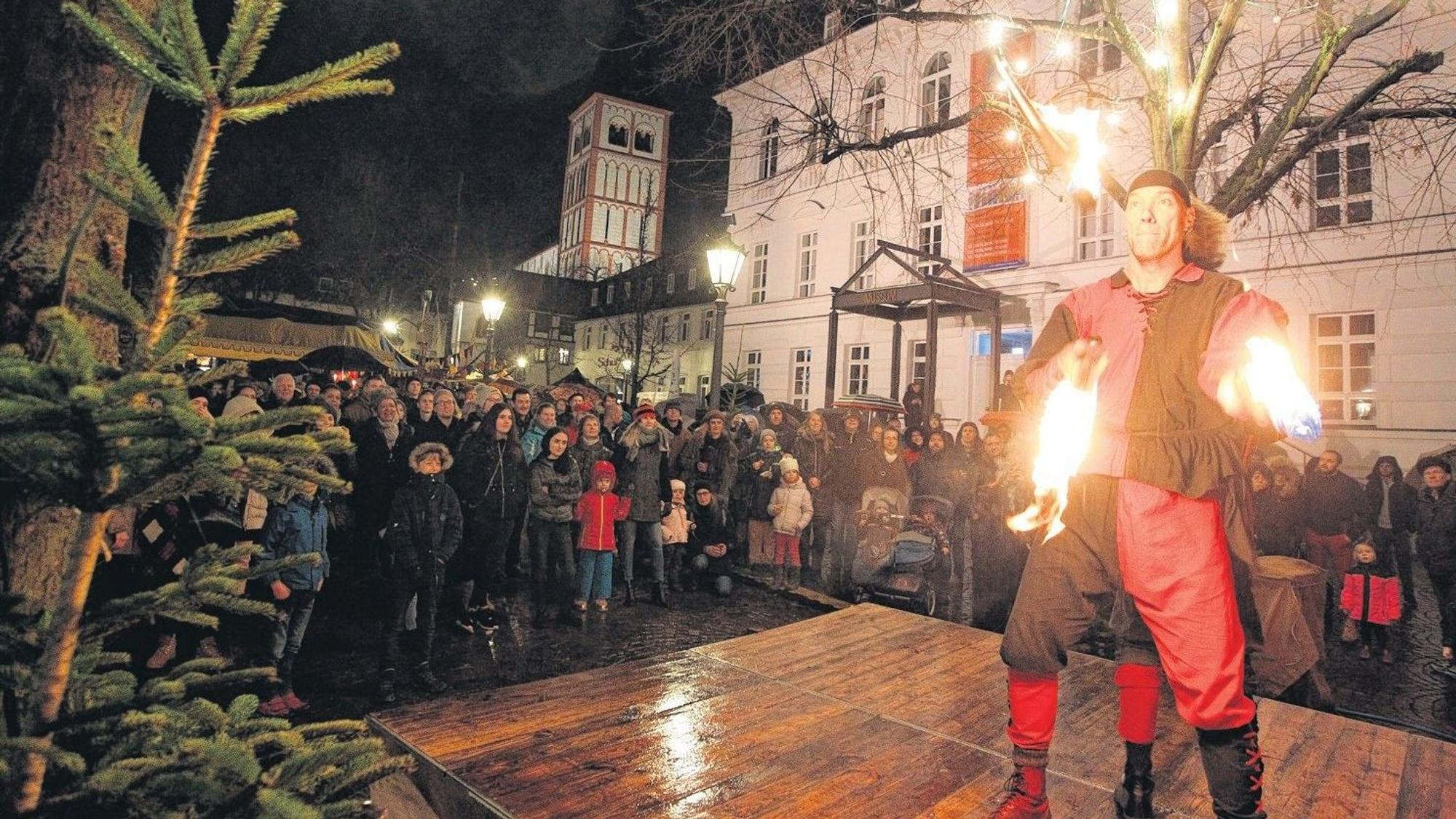 Ein Jongleur jongliert mit brennenden Keulen auf der Bühne am Stadtmuseum
