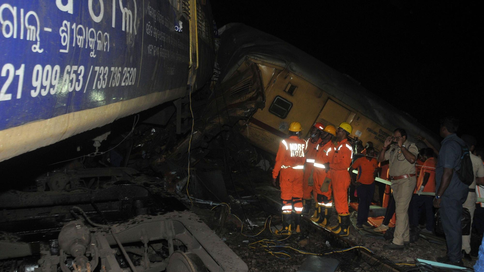 dpatopbilder - 29.10.2023, Indien, Vizianagaram: Rettungskräfte und andere Personen stehen nach dem Zusammenstoß zweier Personenzüge am Unfallort. Der Unfall ereignete sich, als ein herannahender Zug auf einen stehenden Zug auffuhr, wodurch mindestens drei Waggons entgleisten. Foto: Uncredited/AP/dpa +++ dpa-Bildfunk +++