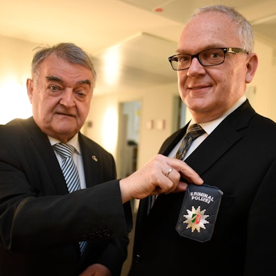 NRW-Innenminister Herbert Reul präsentiert im April 2022 mit Landeskriminaldirektor Johannes Hermanns die neue Polizeidienstmarke, mit der sich Kriminalbeamte ausweisen.