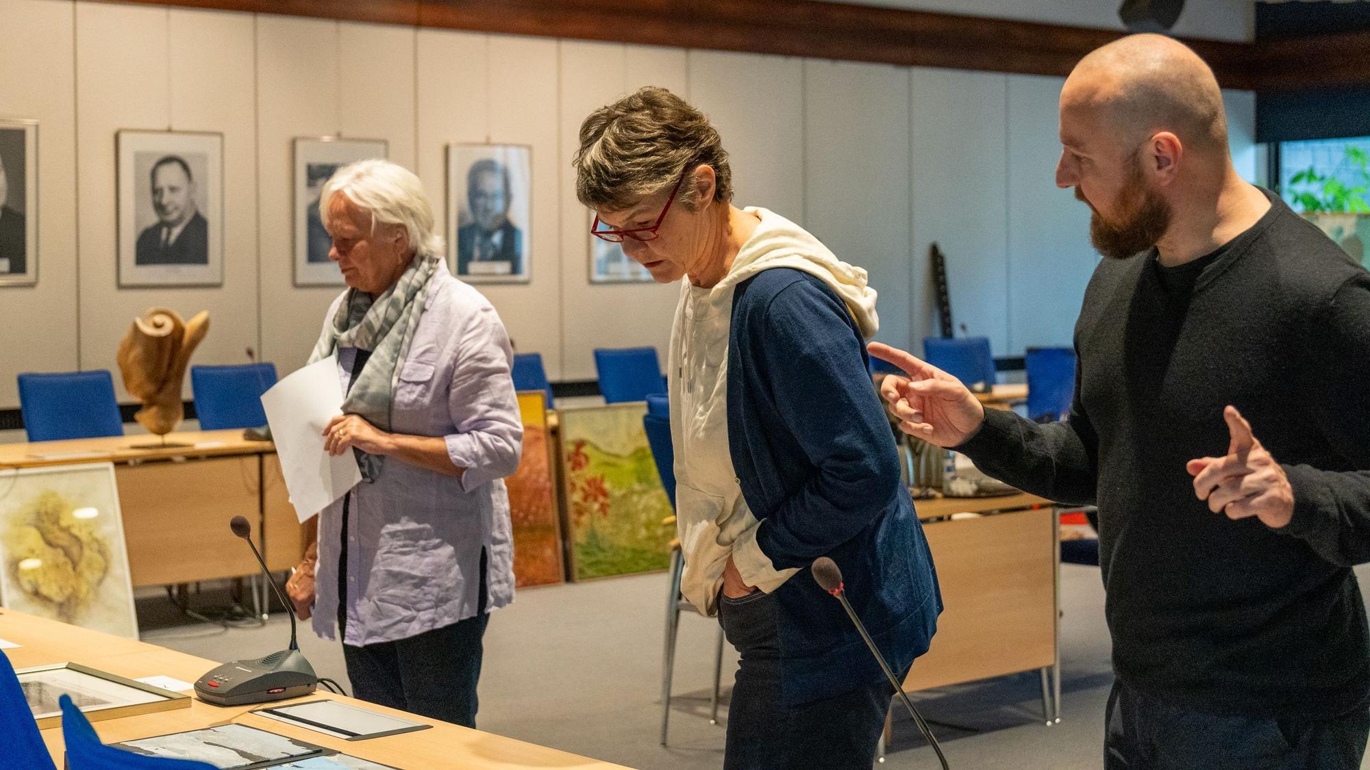 Beate Domdey-Fehlau (v.l.), Astrid Bardenheuer und Damian Zimmermann betrachten die eingereichten Werke.