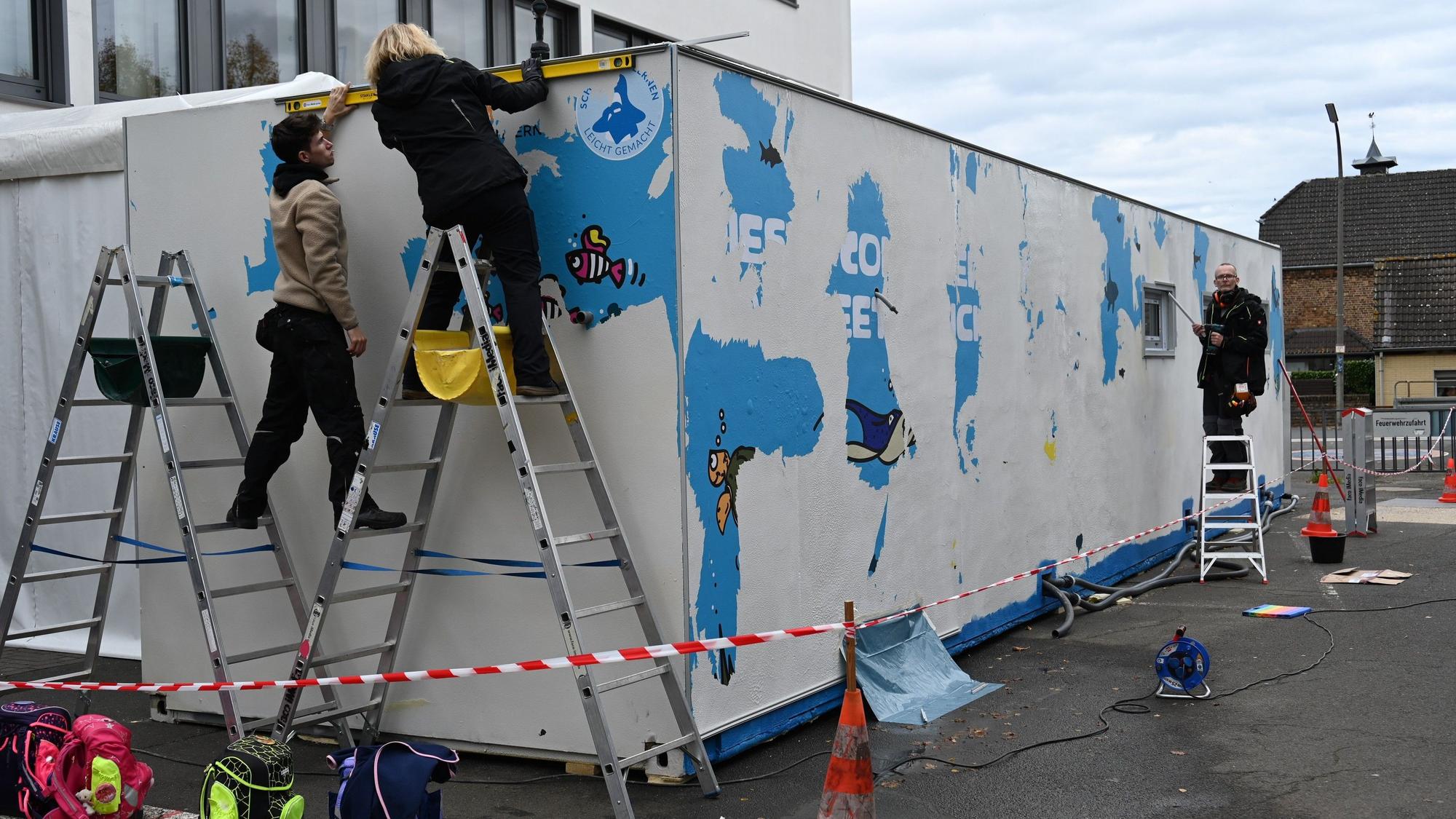 An einem großen Container wird gearbeitet.
