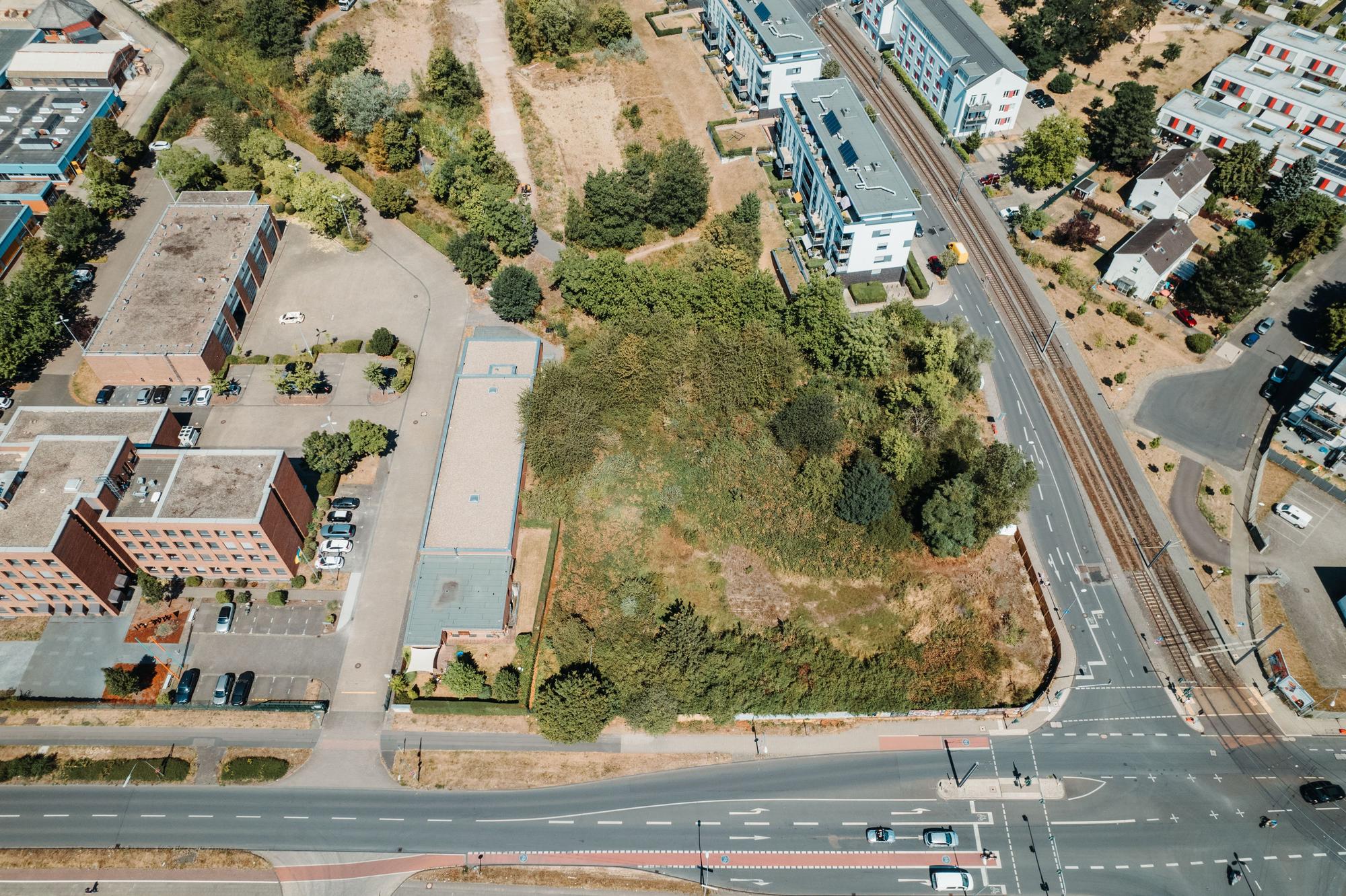 Eine Straßenkreuzung in Ossendorf, an deren Ecke eine Grünfläche ist.
