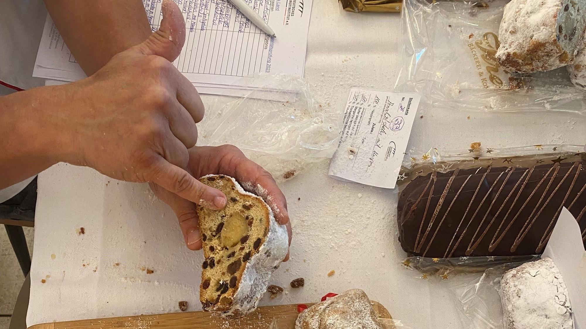 Der Stollenprüfer zeigt auf die Textur eines Weihnachtsstollens mit Marzipan.