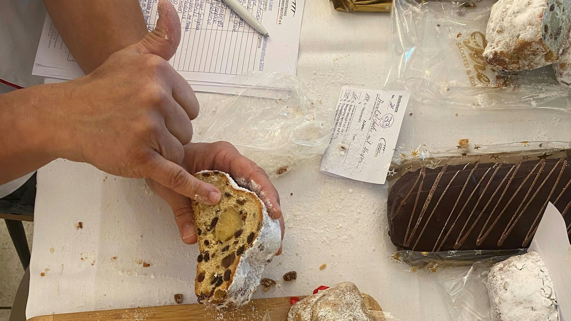 Der Stollenprüfer zeigt auf die Textur eines Weihnachtsstollens mit Marzipan.