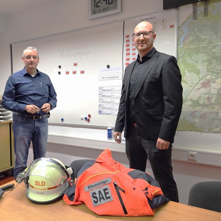 Wolfgang Fuchs (l.), Leiter der Stabsstelle für den Katastrophenschutz, und Bürgermeister Ingo Pfennings stehen vor einer Schreibtafel mit dem Wort Katastrophe.