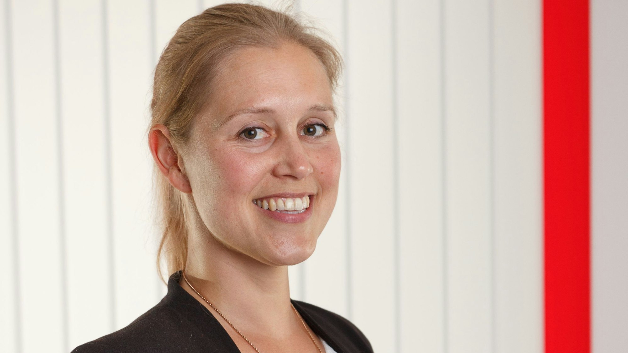 Eine Frau lächelt in die Kamera.