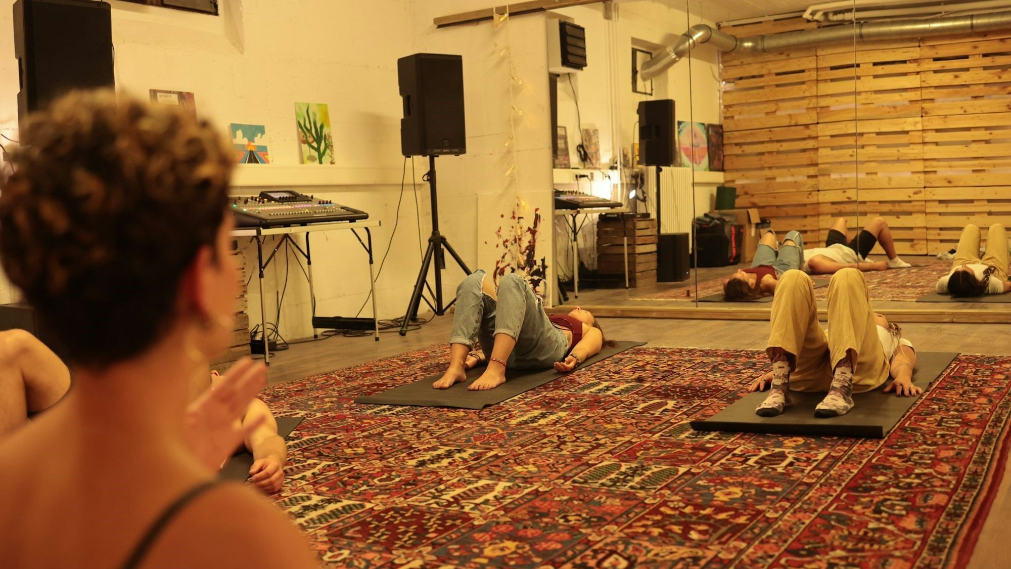 Zwei Menschen liegen auf einer Yogamatte.