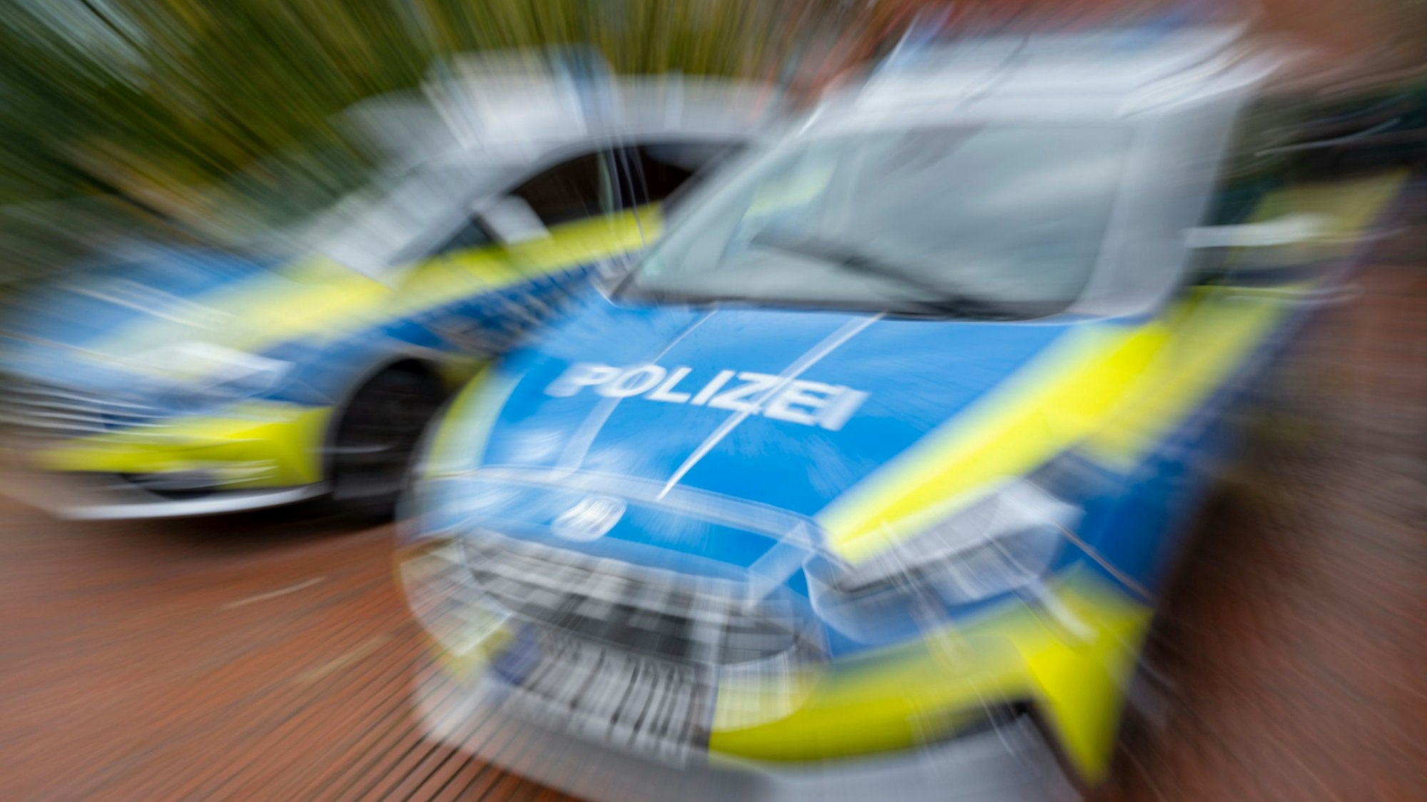 Zwei Polizeiautos stehen auf der Straße.