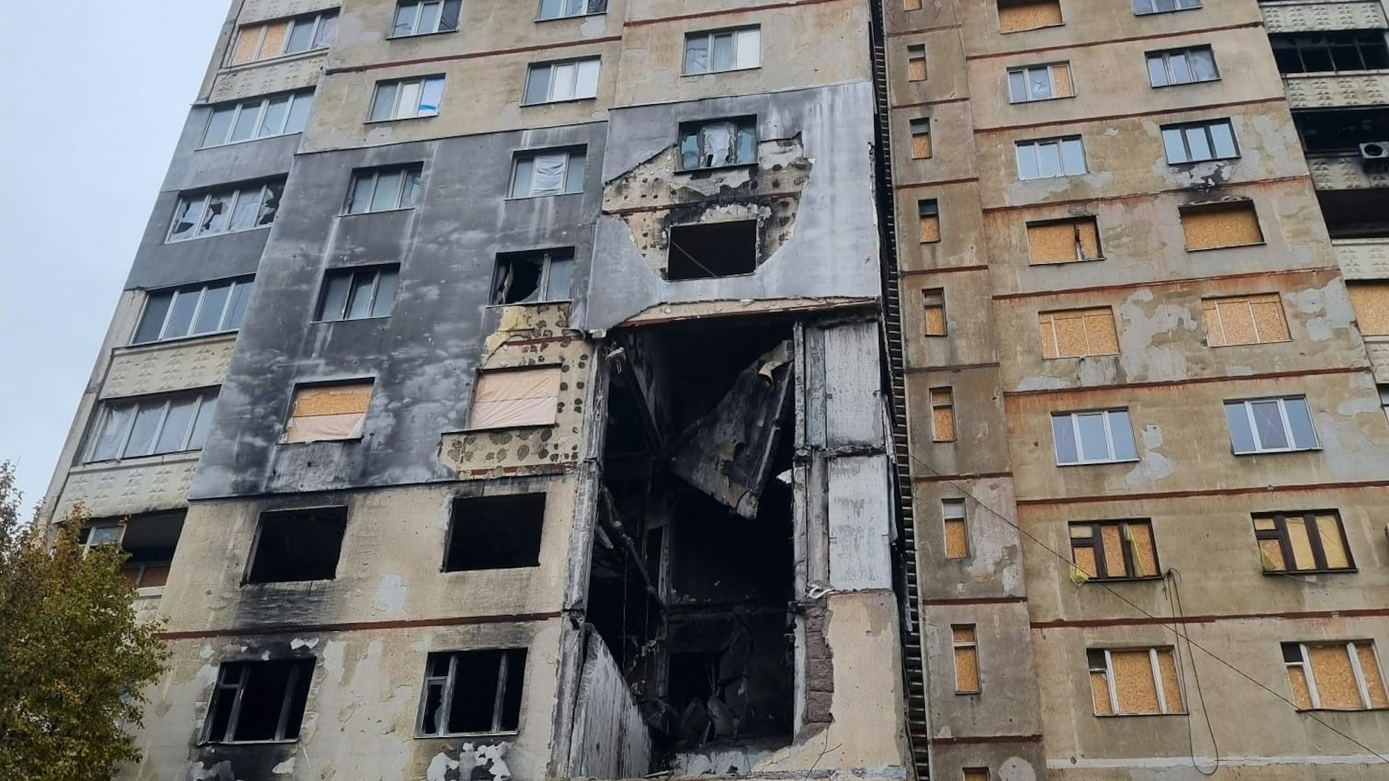 In einem Hochhaus klafft nach Bombardierungen ein riesiges Loch in der Fassade.
