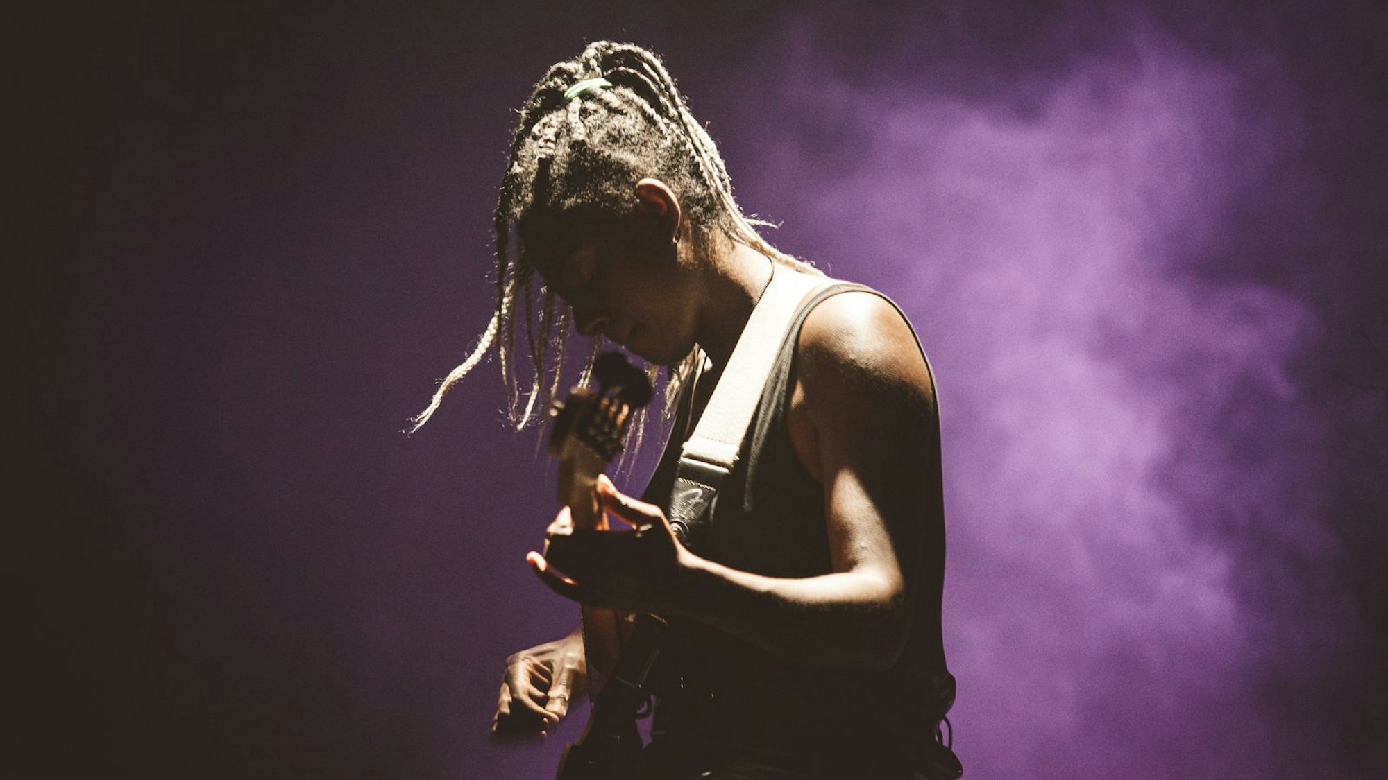 Farida Amadou spielt Bass auf einer Bühne.