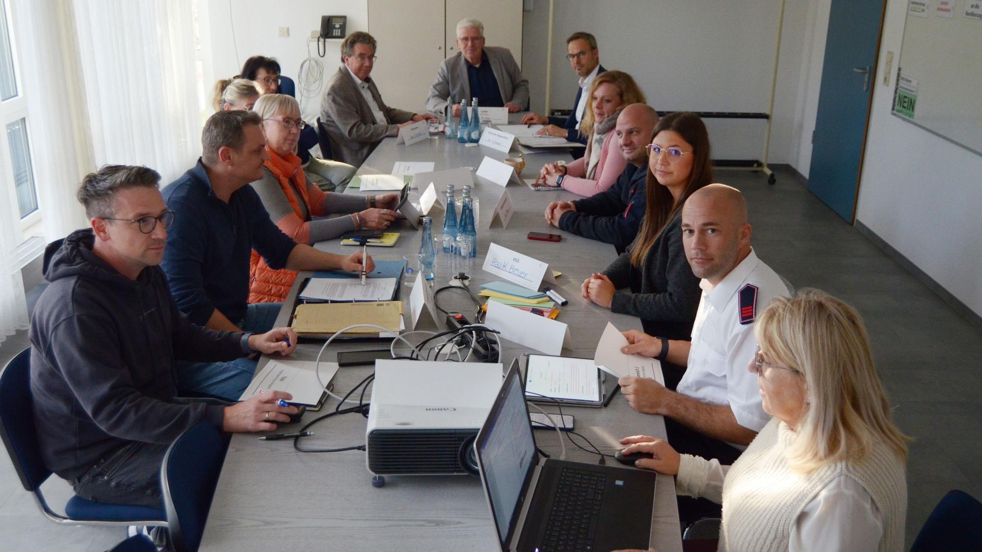 Mitarbeiter der Euskirchener Stadtverwaltung sitzen in einem Konferenzraum mit sorgenvollen Blicken an einem Tisch.