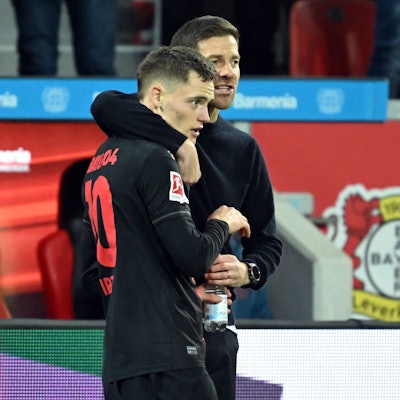 Bayer Leverkusen's German midfielder #10 Florian Wirtz (L) speaks with Bayer Leverkusen's Spanish coach Xabi Alonso during the German first division Bundesliga football match between Bayer 04 Leverkusen and SC Freiburg in Leverkusen, western Germany on October 29, 2023. (Photo by INA FASSBENDER / AFP) / DFL REGULATIONS PROHIBIT ANY USE OF PHOTOGRAPHS AS IMAGE SEQUENCES AND/OR QUASI-VIDEO