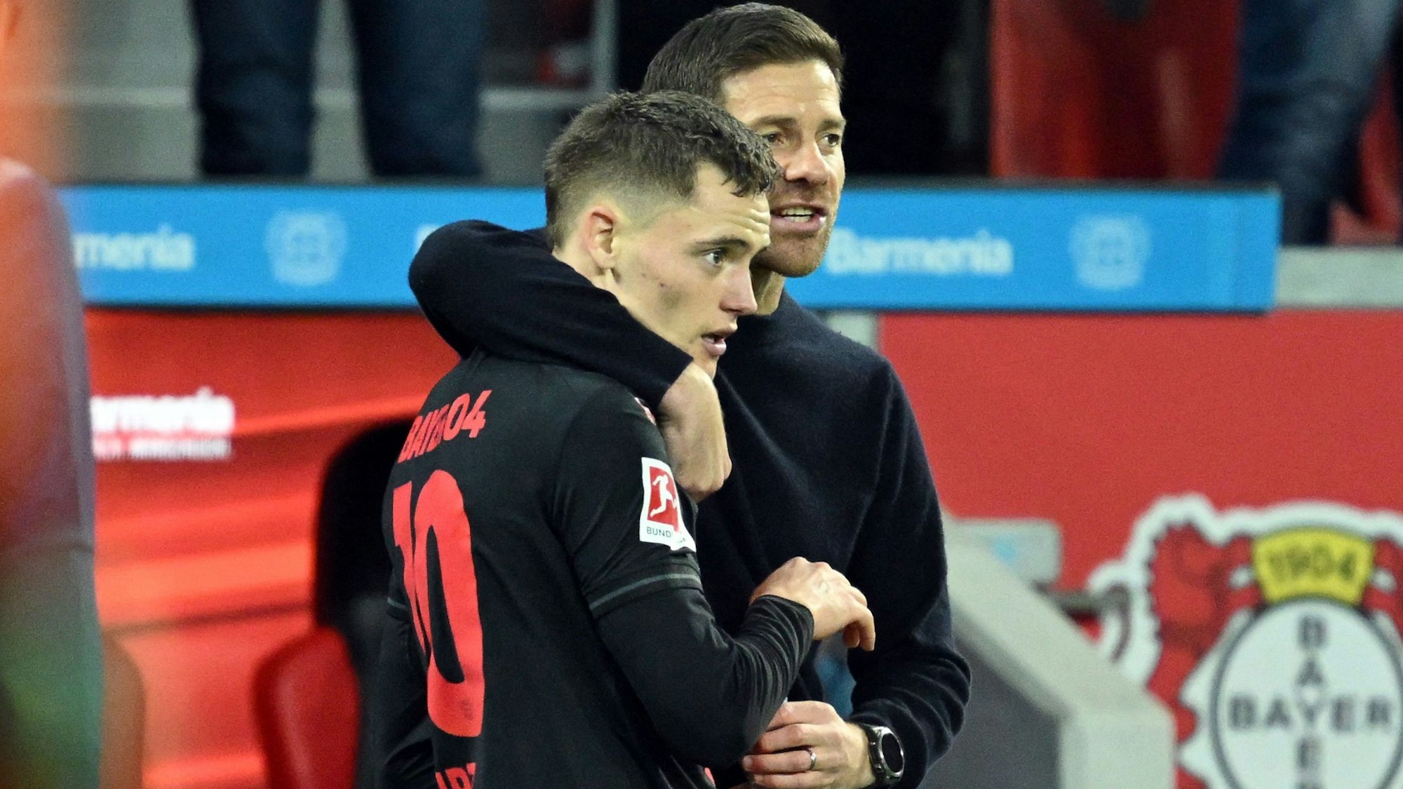 Bayer Leverkusen's German midfielder #10 Florian Wirtz (L) speaks with Bayer Leverkusen's Spanish coach Xabi Alonso during the German first division Bundesliga football match between Bayer 04 Leverkusen and SC Freiburg in Leverkusen, western Germany on October 29, 2023. (Photo by INA FASSBENDER / AFP) / DFL REGULATIONS PROHIBIT ANY USE OF PHOTOGRAPHS AS IMAGE SEQUENCES AND/OR QUASI-VIDEO