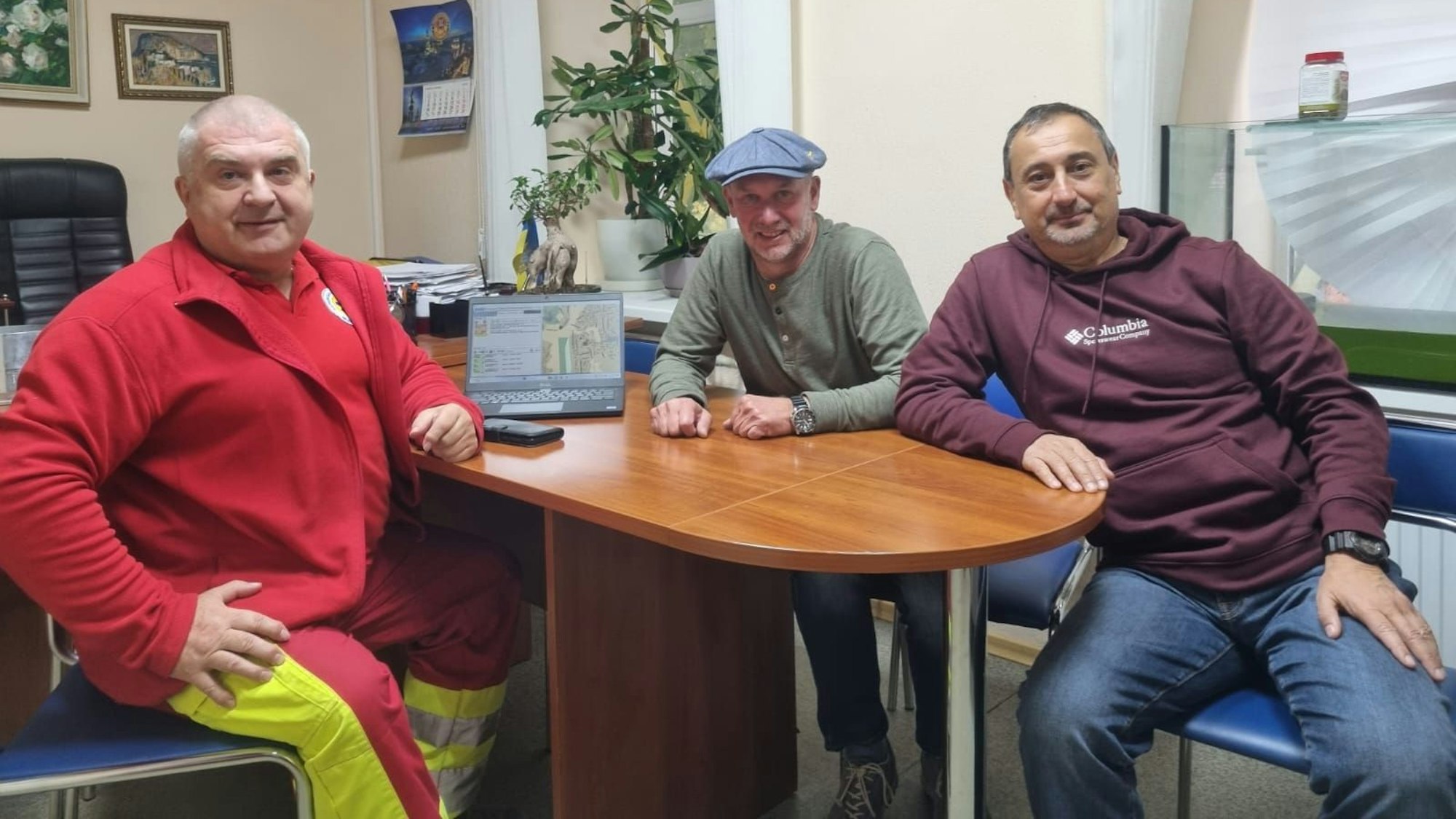 Zwei Männer im Gespräch mit einem ukrainischen Rettungssanitäter.