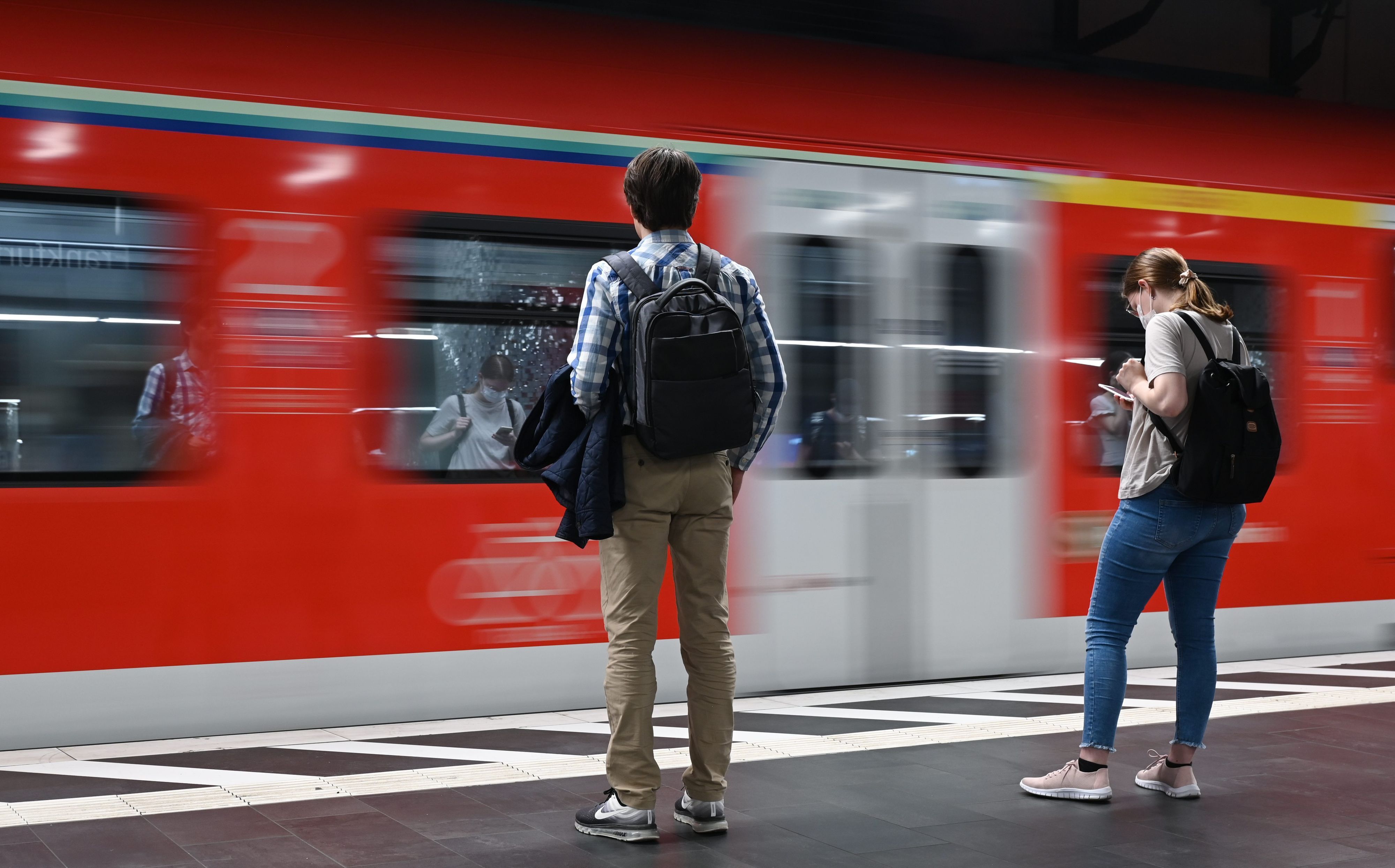 Hessen, Frankfurt/Main: Zugreisende warten im Hauptbahnhof auf die Einfahrt einer S-Bahn (Aufnahme mit länger Verschlusszeit).