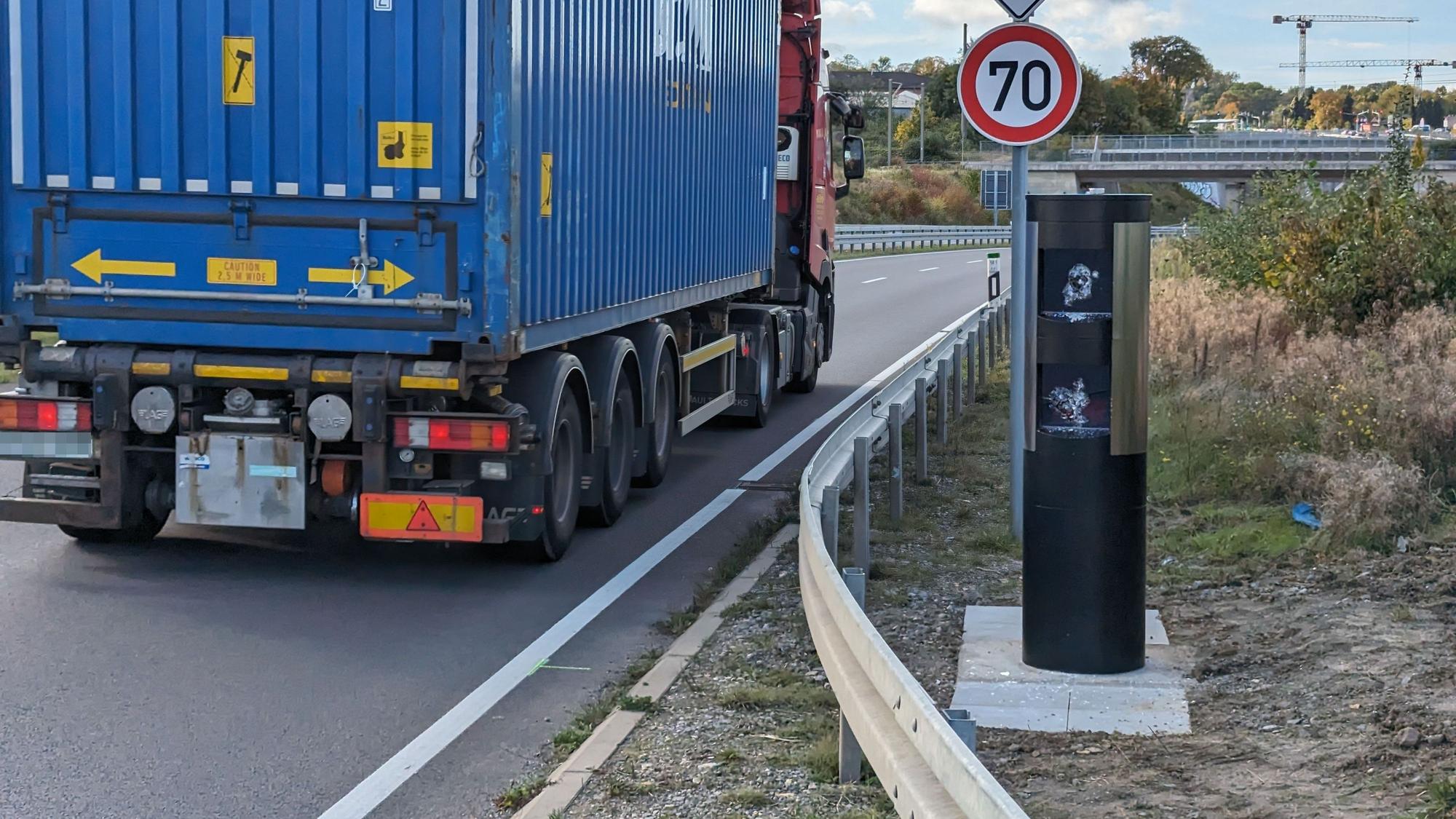 Das Foto zeigt die demolierte Lasermessanlage in Hürth. Ein Lkw passiert die Stelle.