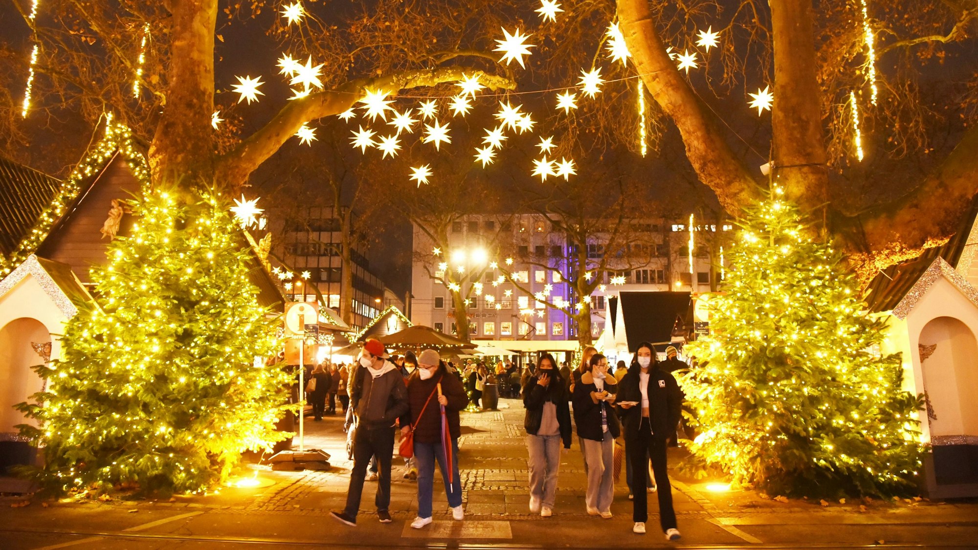 Menschen gehen über den Weihnachtsmarkt am Neumarkt.