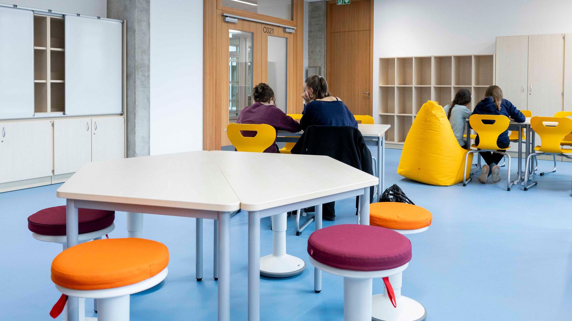 Schülerinnen sitzen an einem Tisch in einem Betreuungsraum und lernen.