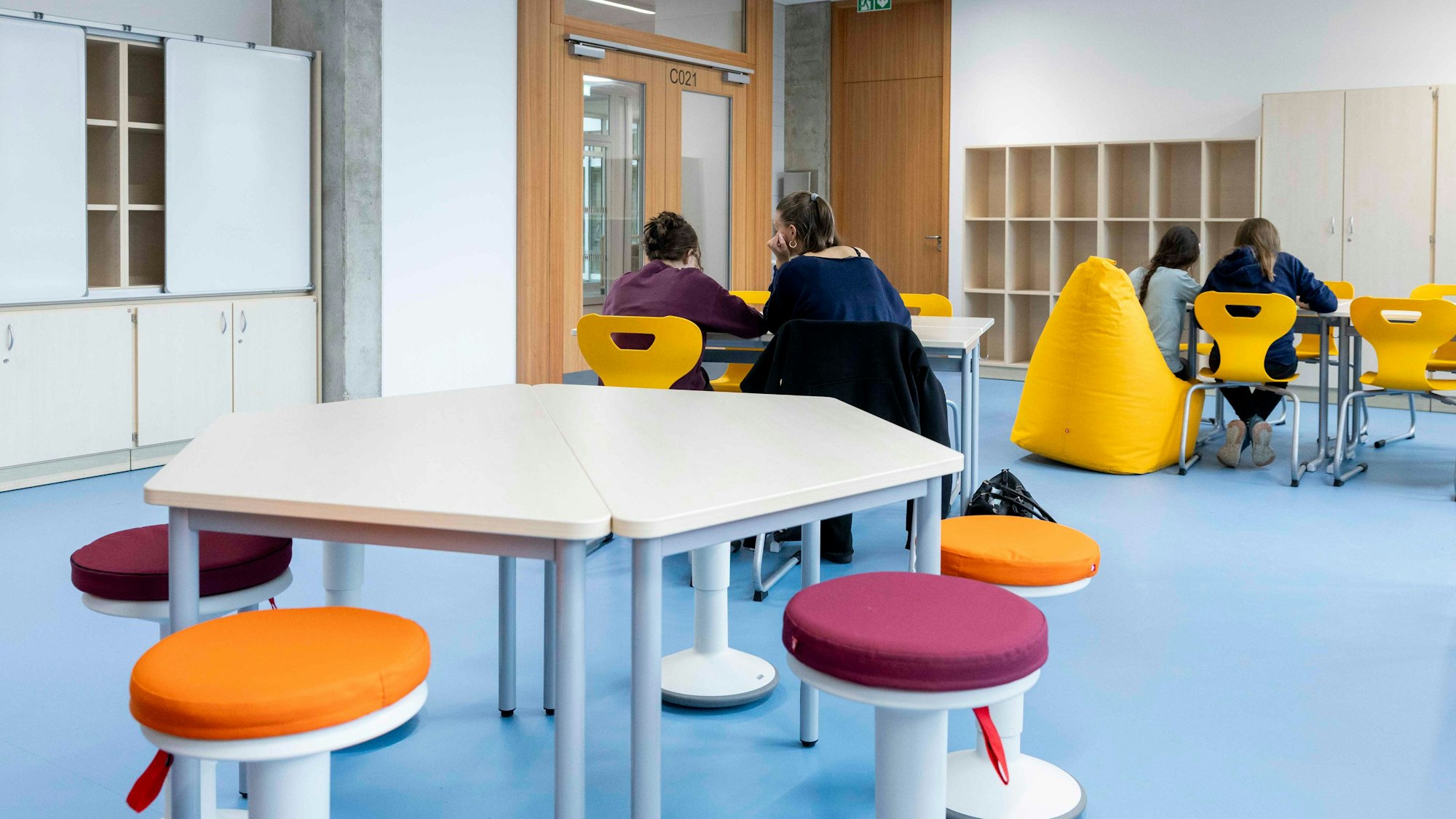 Schülerinnen sitzen an einem Tisch in einem Betreuungsraum und lernen.