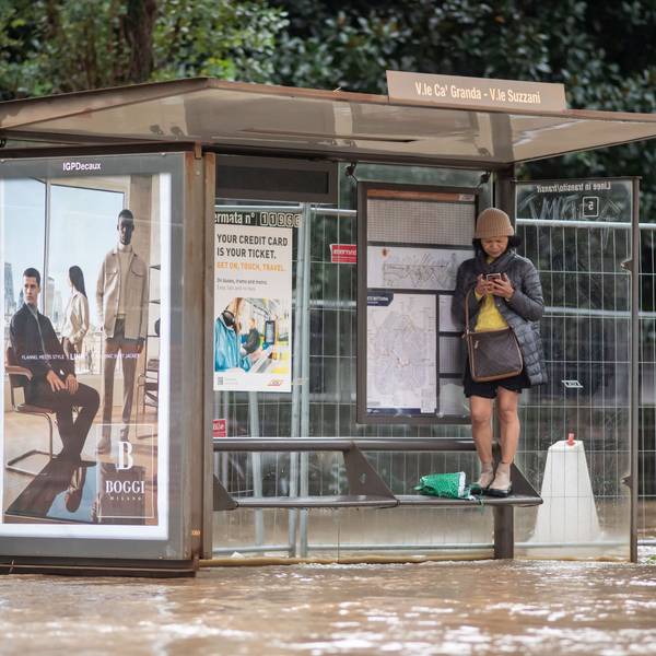 Eine Frau steht auf einer Sitzbank einer Bushaltestelle in Mailand. Die Stadt wurde nach schweren Regenfällen teilweise meterhoch überschwemmt.