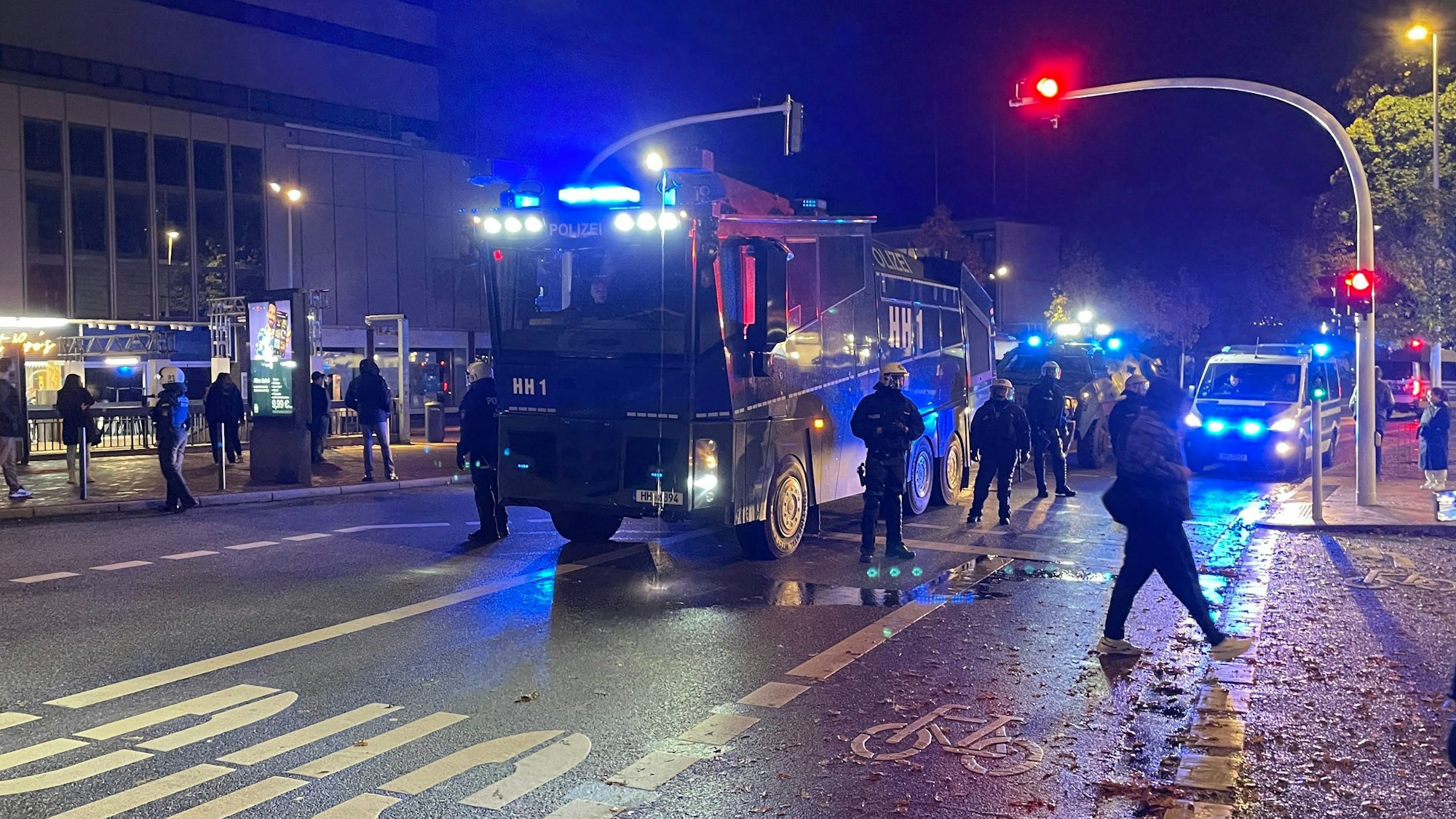 31.10.2023, Hamburg: Einsatzkräfte der Polizei stehen neben Einsatzfahrzeugen in Harburg.