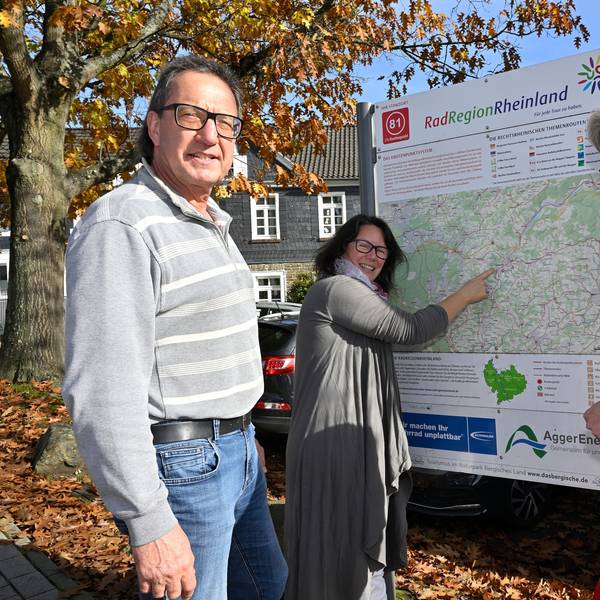 Drei Menschen stehen vor einer Radwegekarte.