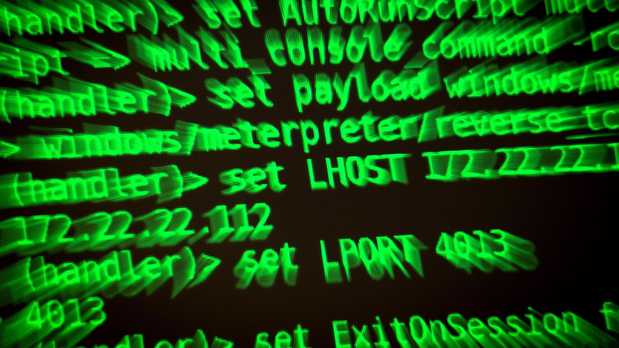 Buchstaben und Zahlen leuchten auf einem Bildschirm, auf dem ein Hacker-Programm geöffnet ist.