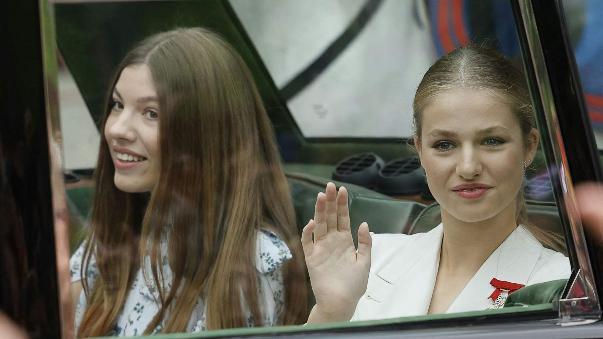 Die spanische Kronprinzessin Leonor (r) und Infantin Sofia (l) winken auf dem Weg zur Vereidigung im Abgeordnetenhaus.