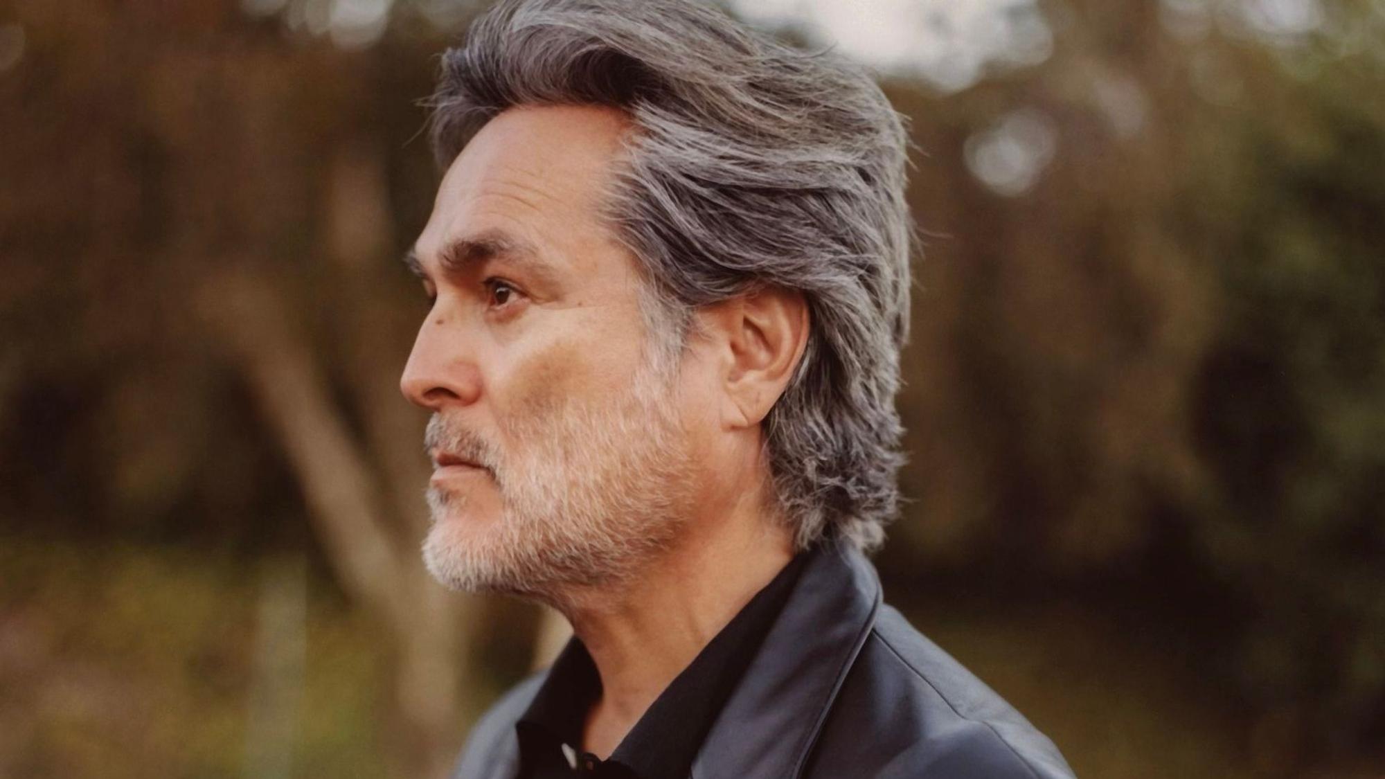 Eddie Chacon schaut im Profil nach links. Seine Haare sind grau und nach hinten gekämmt, sein kurz gestutzter Vollbart ist weiß.