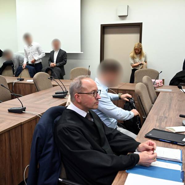 Die Angeklagten warten mit ihren Rechtsanwälten auf den Beginn des Prozesses.
