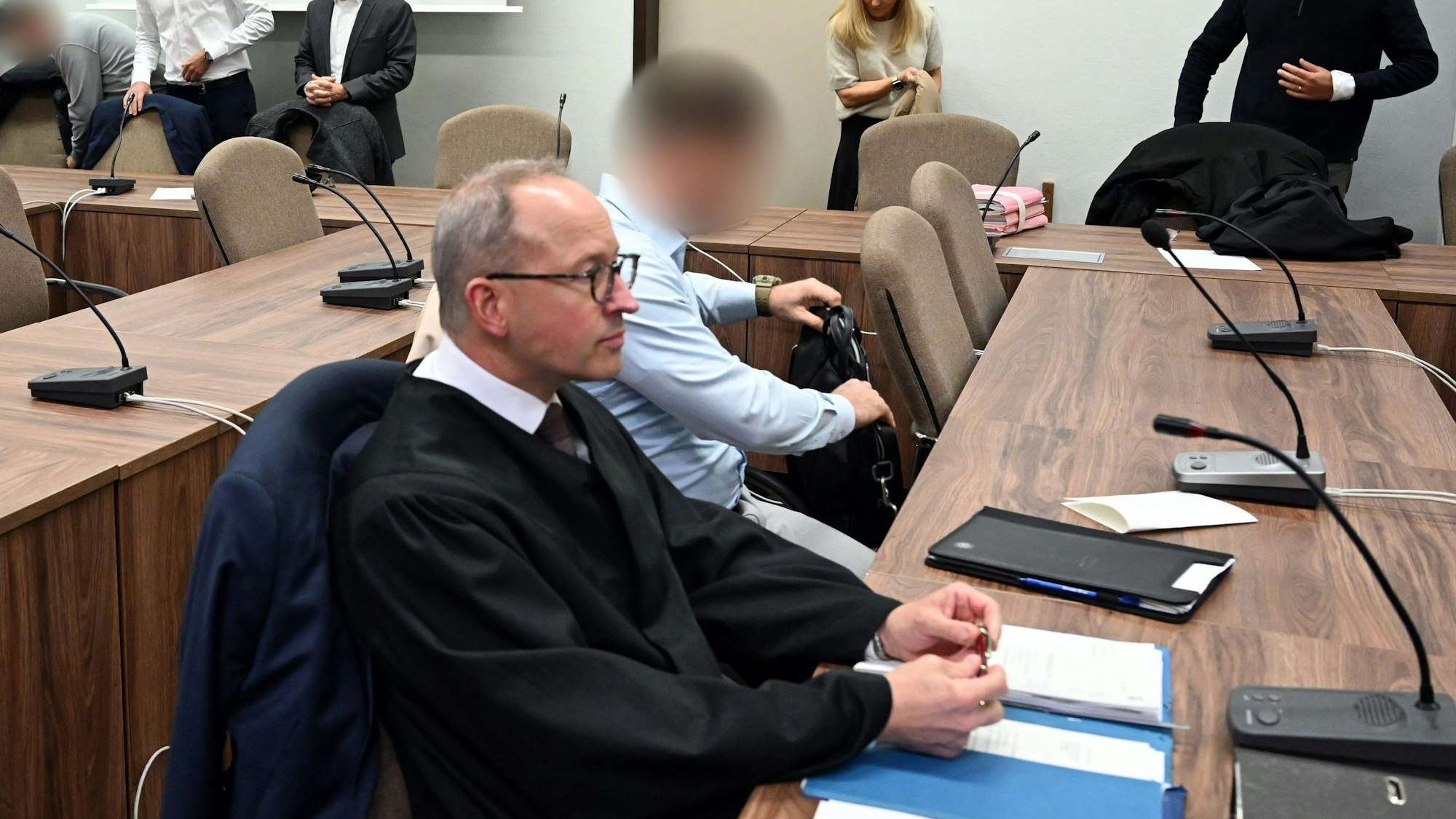 Die Angeklagten warten mit ihren Rechtsanwälten auf den Beginn des Prozesses.
