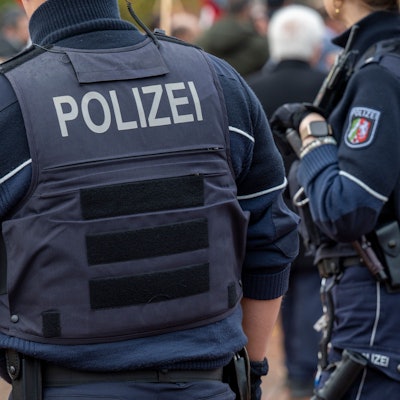 Zwei Polizisten stehen auf einem Weg.