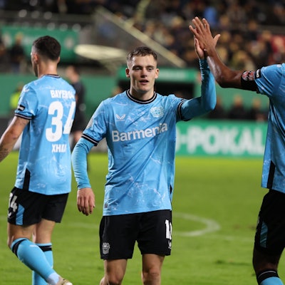 Leverkusens Florian Wirtz (l) und Jonathan Tah klatschen nach dem Spiel gegen den SV Sandhausen ab.