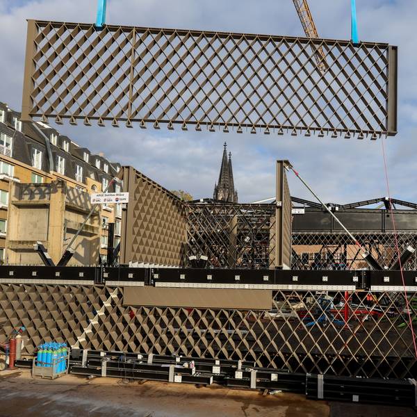 Ein Stahlbauteil in Rautenform hängt an einem Kran und wird eingesetzt.