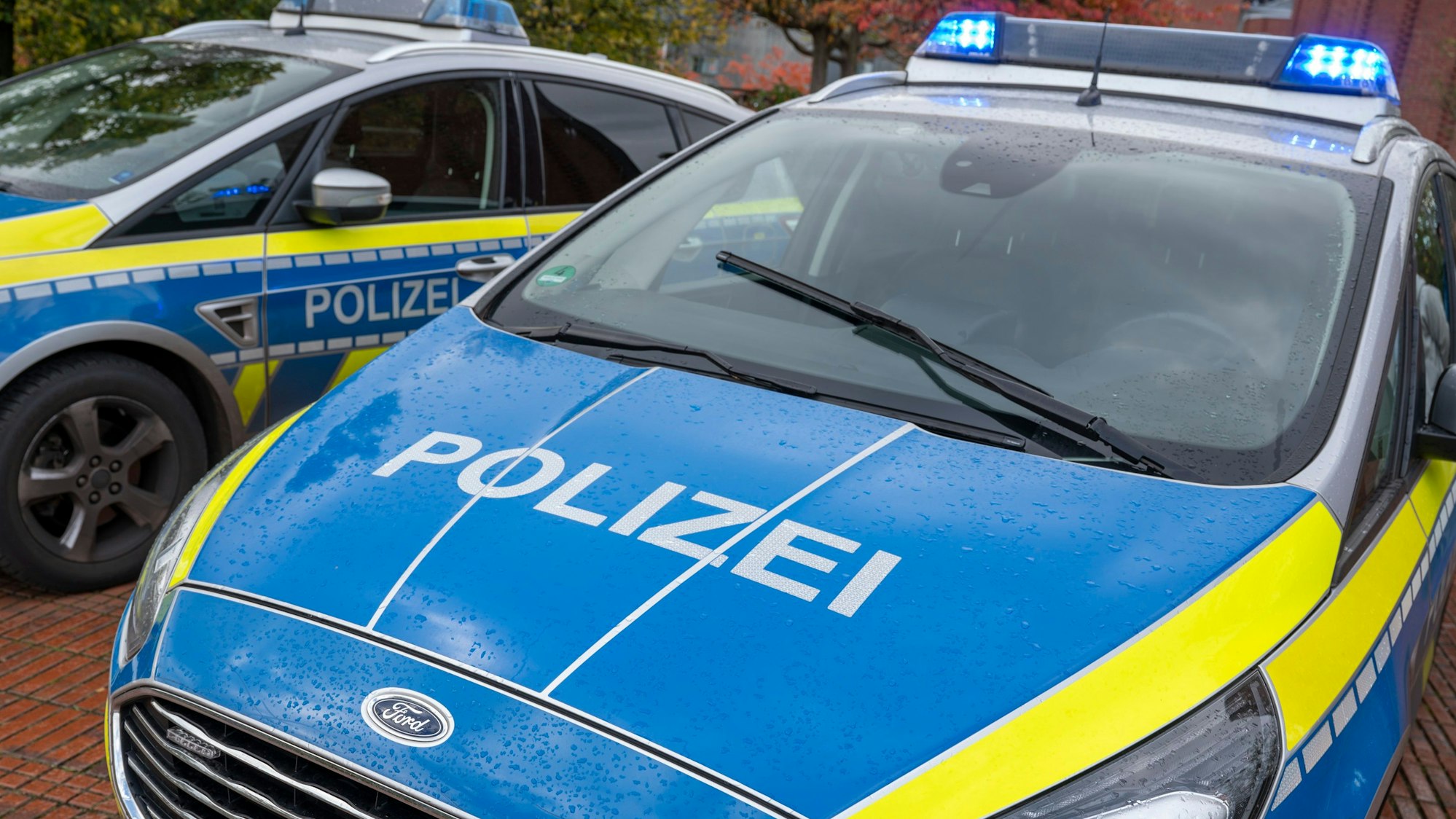 Zu sehen sind zwei Fahrzeuge mit der Aufschrift "Polizei" in der Vorderansicht.