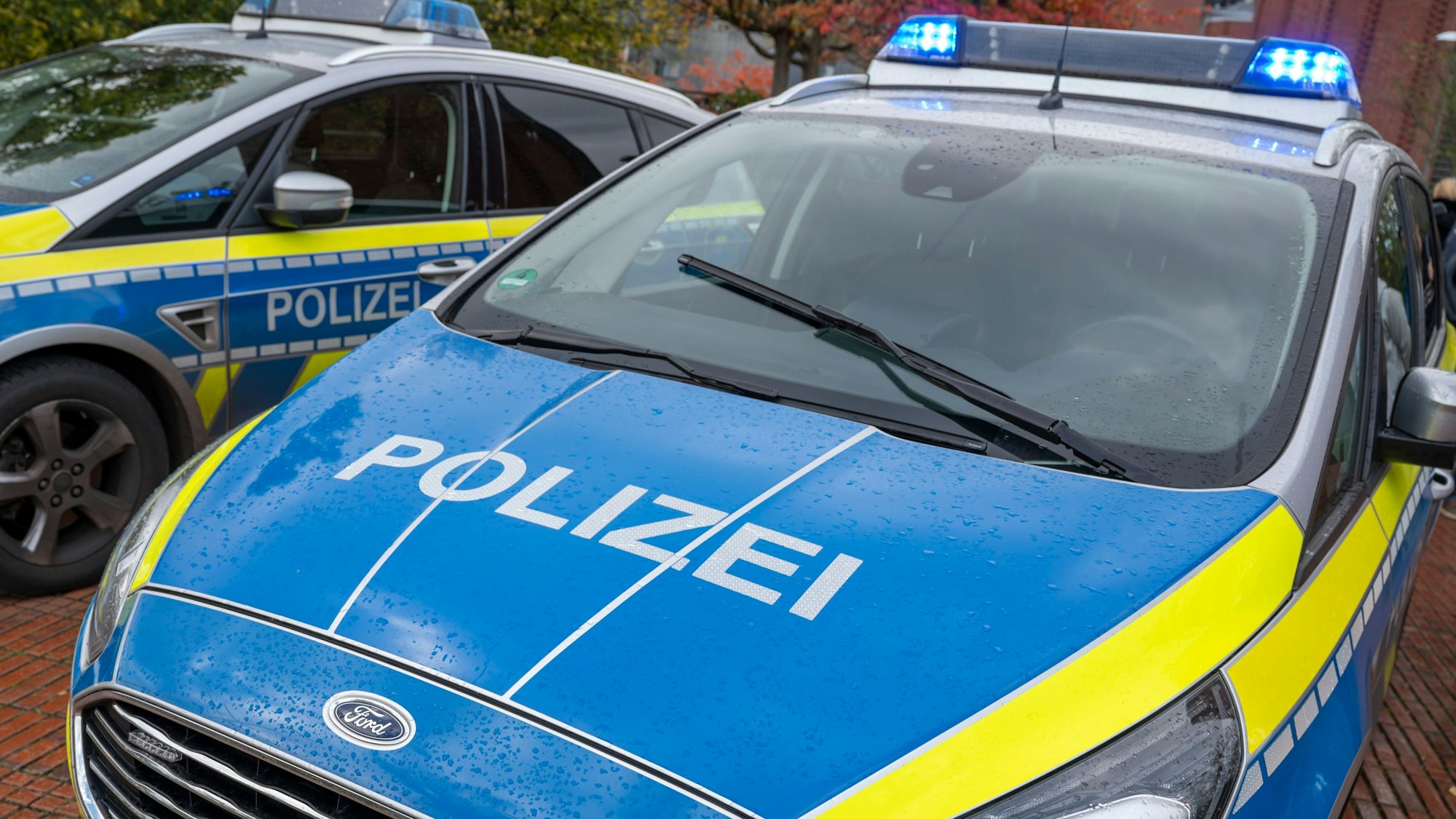 Zu sehen sind zwei Einsatzfahrzeuge der Kölner Polizei, die nebeneinander stehen.