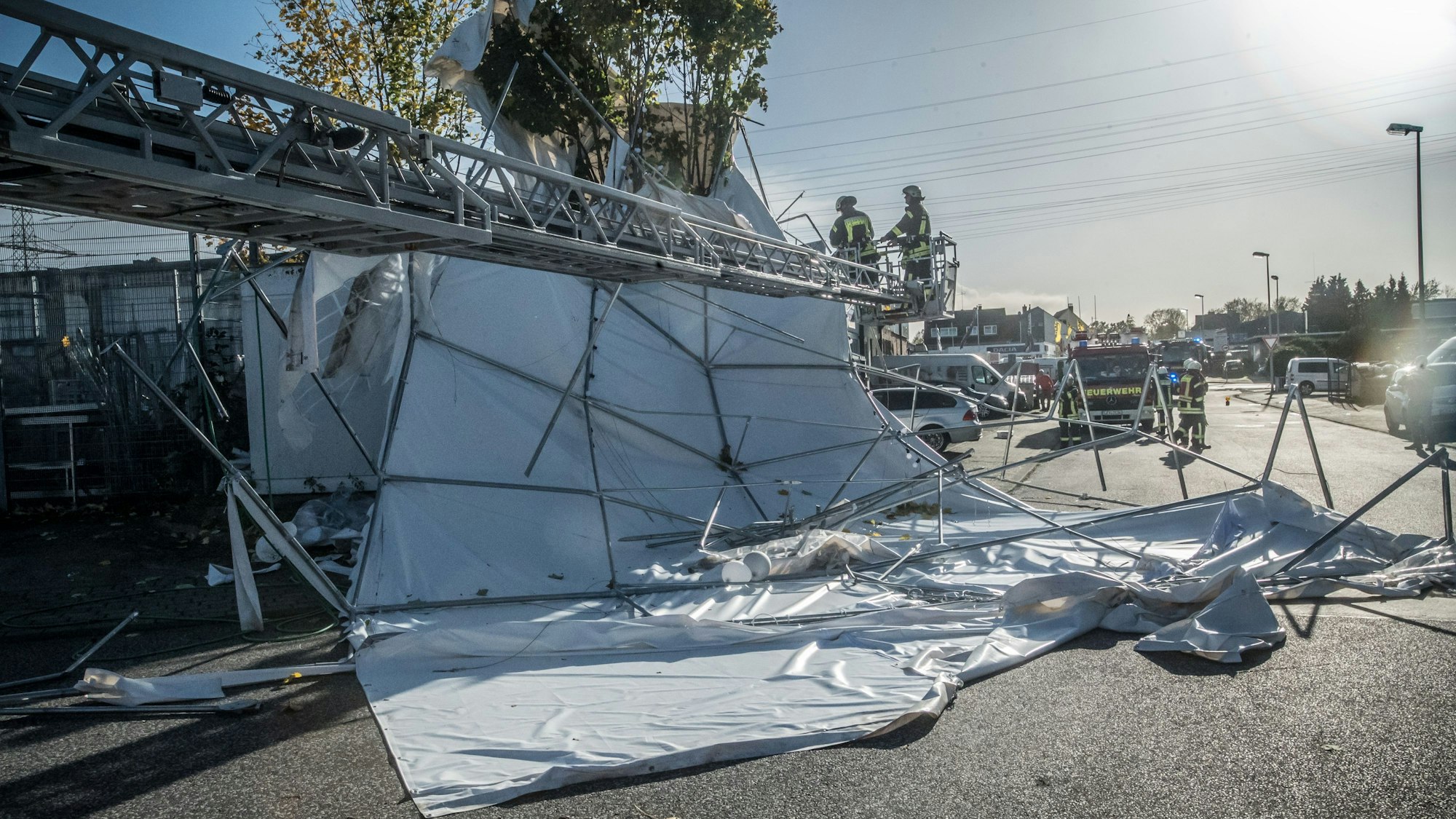 Karl-Ulitzka-Straße: Ein Zelt ist von einem Dach heruntergeweht worden. Die Feuerwehr zerkleinert die Reste.