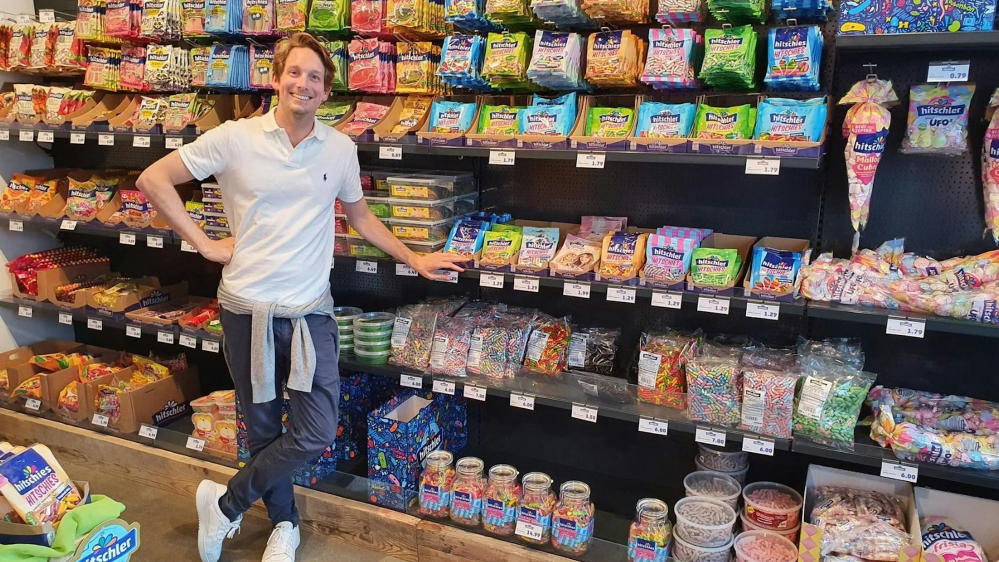 Hitschies-Geschäftsführer Philip Hitschler-Becker vor einem Supermarktregal mitsamt seinen Produkten.