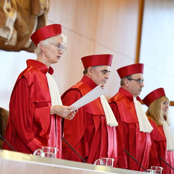 Fünf Richterinnen und Richter des Bundesverfassungsgerichts in roter Robe stehen bei der Verkündung des Urteils zur Verfassungsmäßigkeit der Reform zur Wiederaufnahme von Strafverfahren durch die Vorsitzende Doris König.