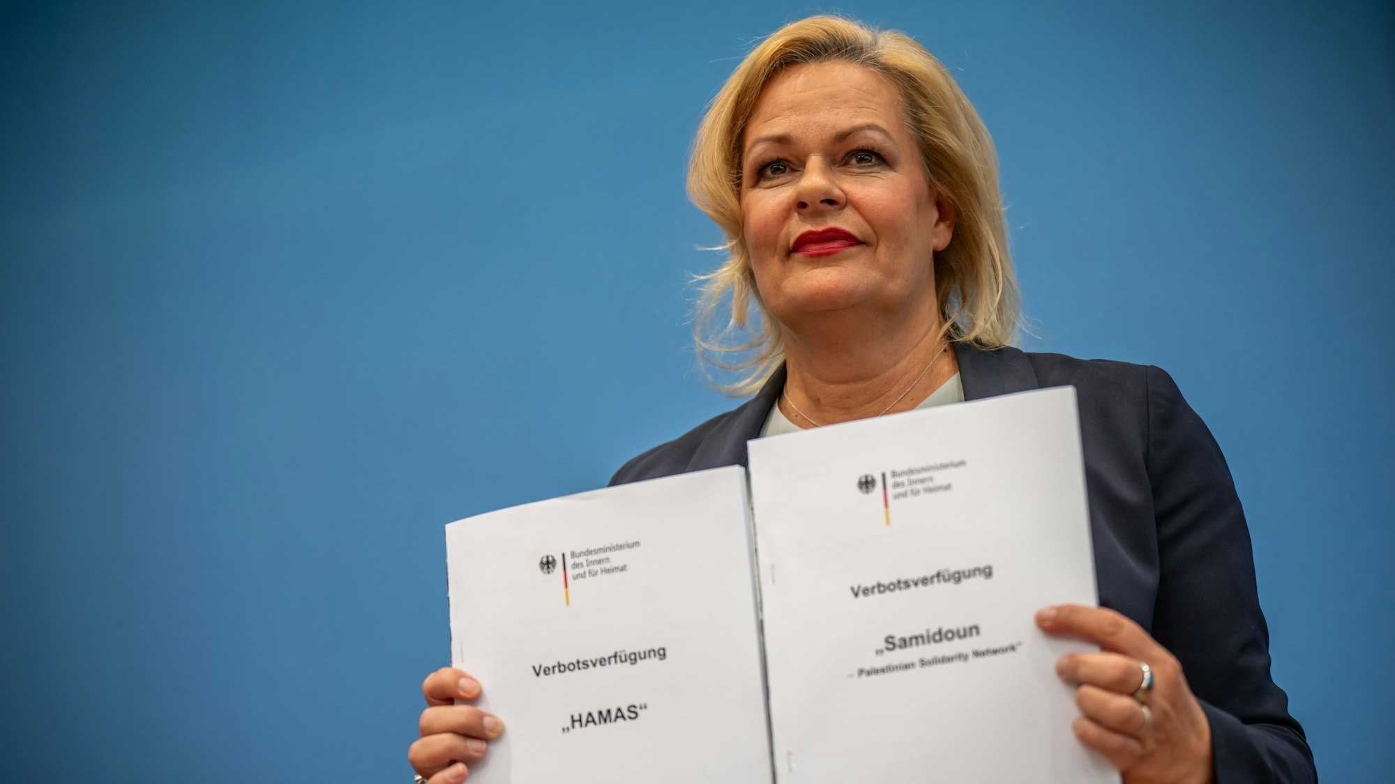 Nancy Faeser (SPD), Bundesministerin des Innern und Heimat, hält eine Verbotsverfügung in den Händen.