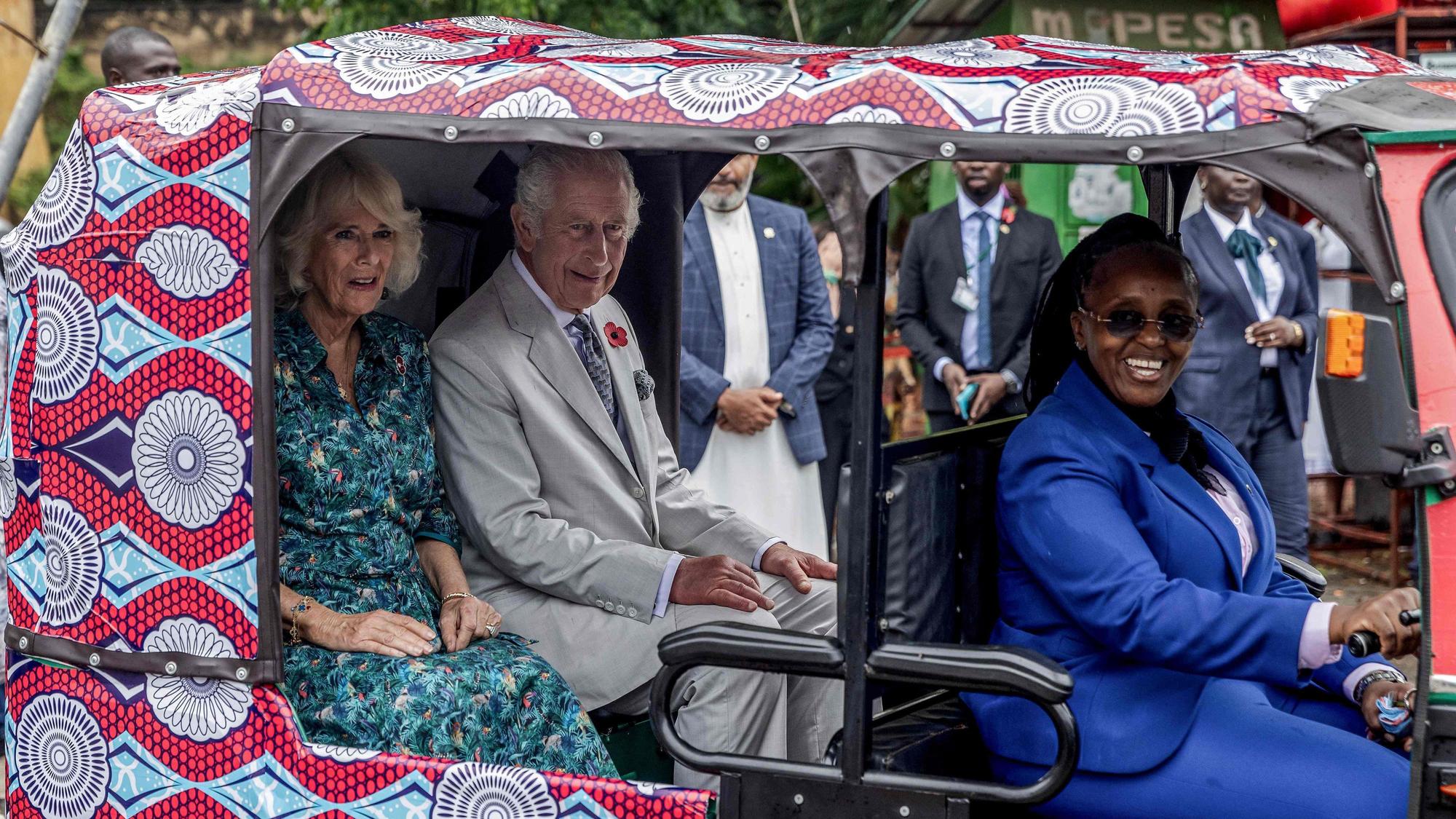 Königin Camilla (l.) und König Charles III. (2. v. l.) sitzen in einem elektrischen Tuktuk mit der Fahrerin des britischen Hochkommissariats, Eunice Karanja (r.), während eines Besuchs von Fort Jesus am Freitag (3. November).