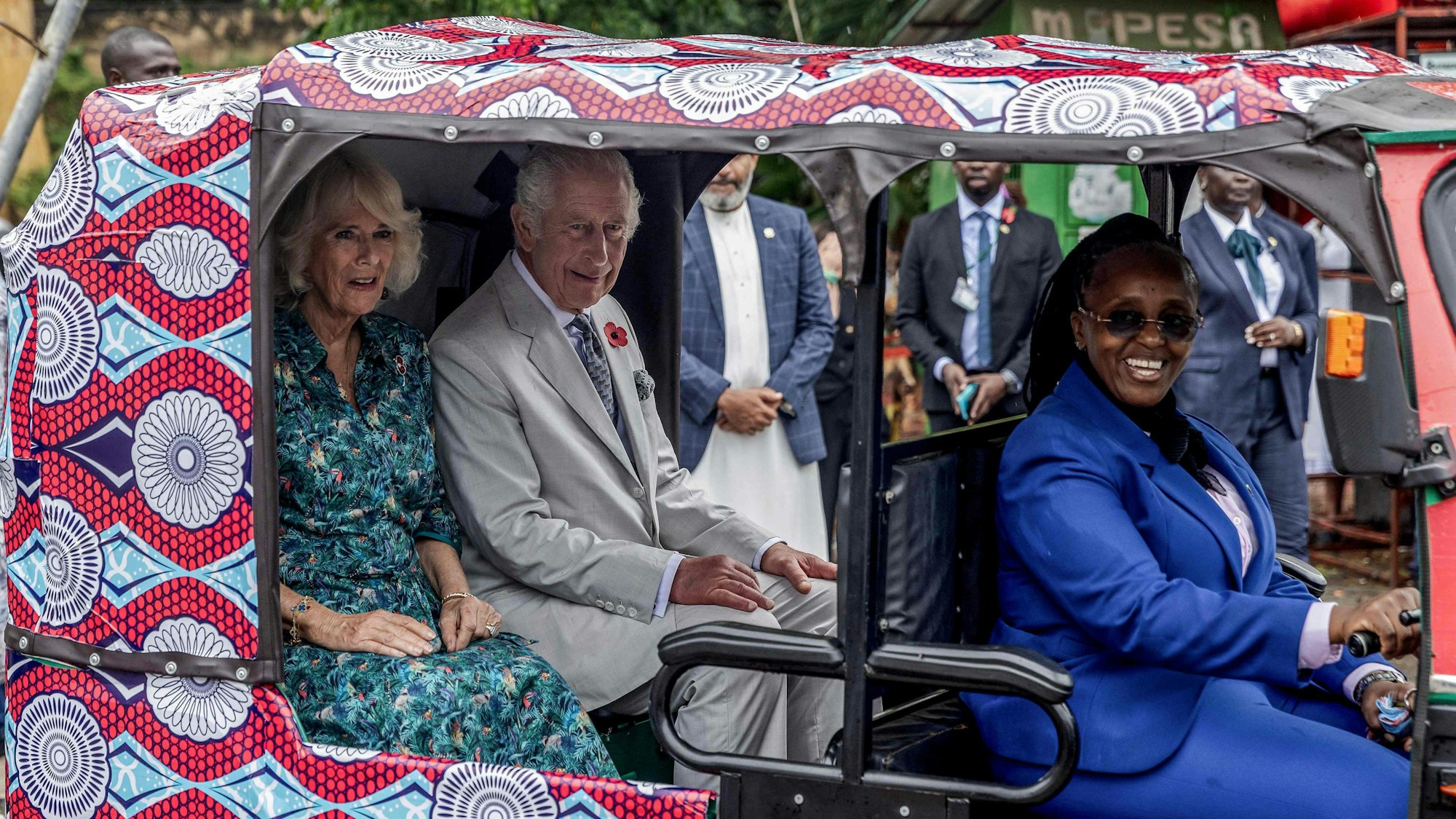 Königin Camilla (l.) und König Charles III. (2. v. l.) sitzen in einem elektrischen Tuktuk mit der Fahrerin des britischen Hochkommissariats, Eunice Karanja (r.), während eines Besuchs von Fort Jesus am Freitag (3. November).