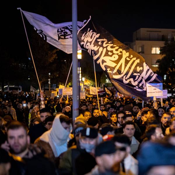 Essen: Eine Fahne mit arabischer Schrift weht bei der Kundgebung über einer Masse von Menschen.