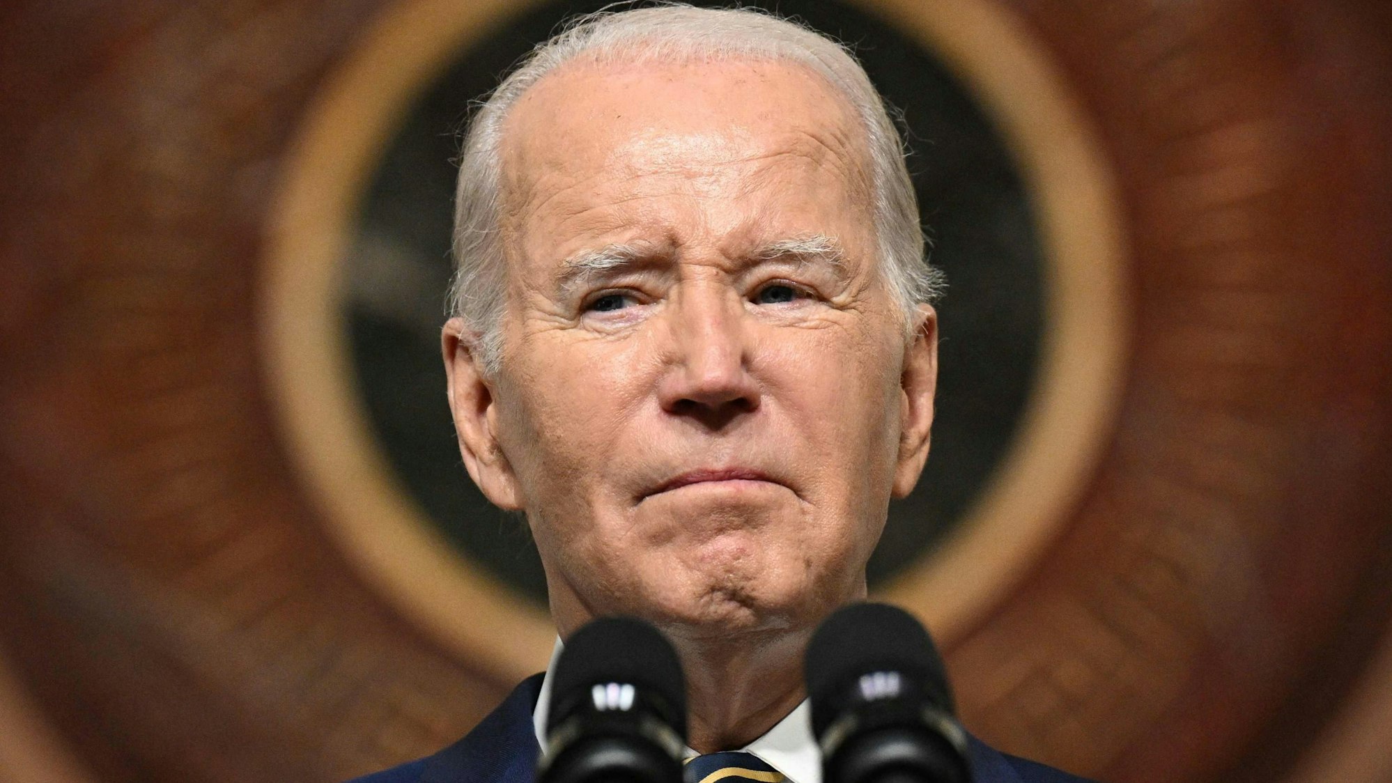 Joe Biden spricht in ein Mikrofon.